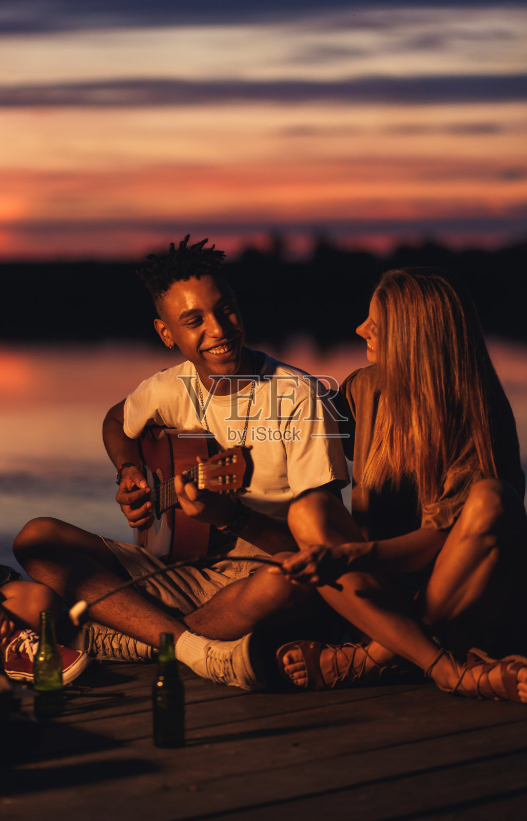 一群年轻的朋友在湖边享受夜晚。一群年轻的朋友在湖边享受夜晚。照片摄影图片