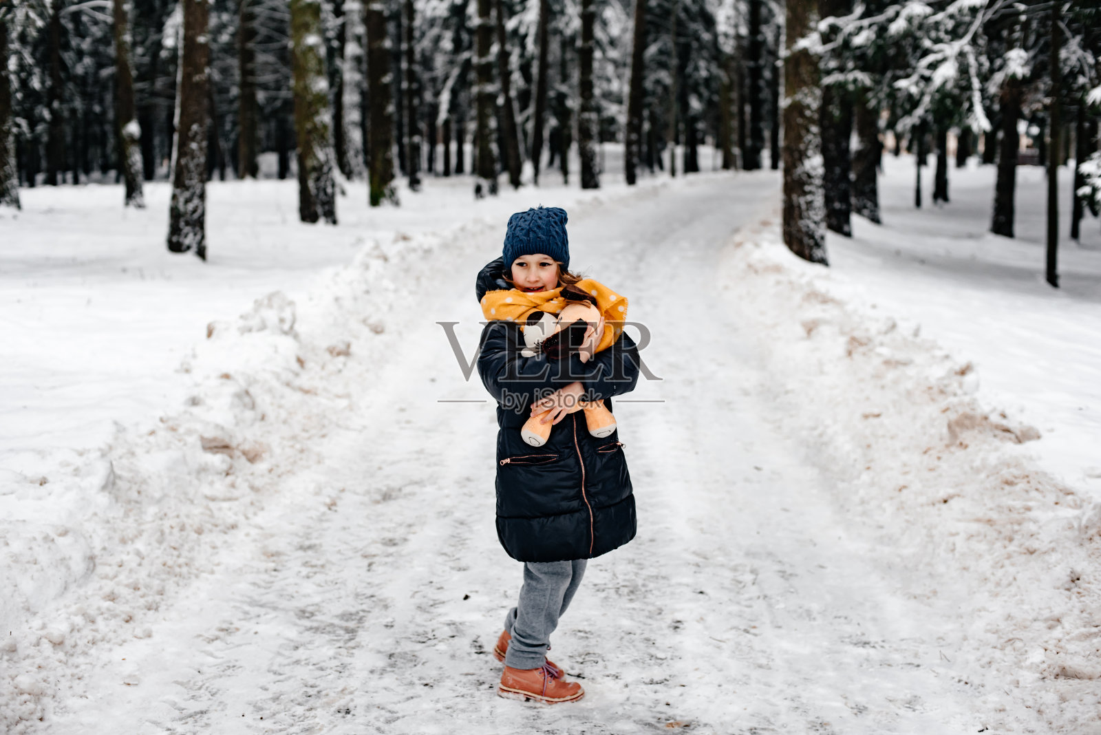 快乐的孩子在冬天走在街上。照片摄影图片