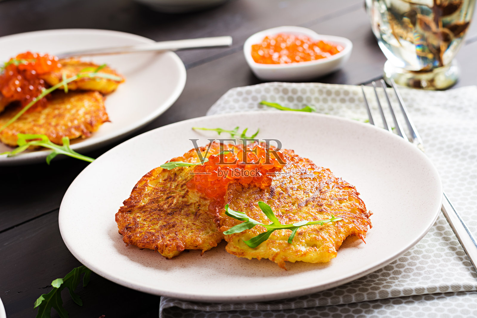 炸土豆煎饼配红鱼子酱和酸奶油，油炸食品。传统美食，午餐。照片摄影图片