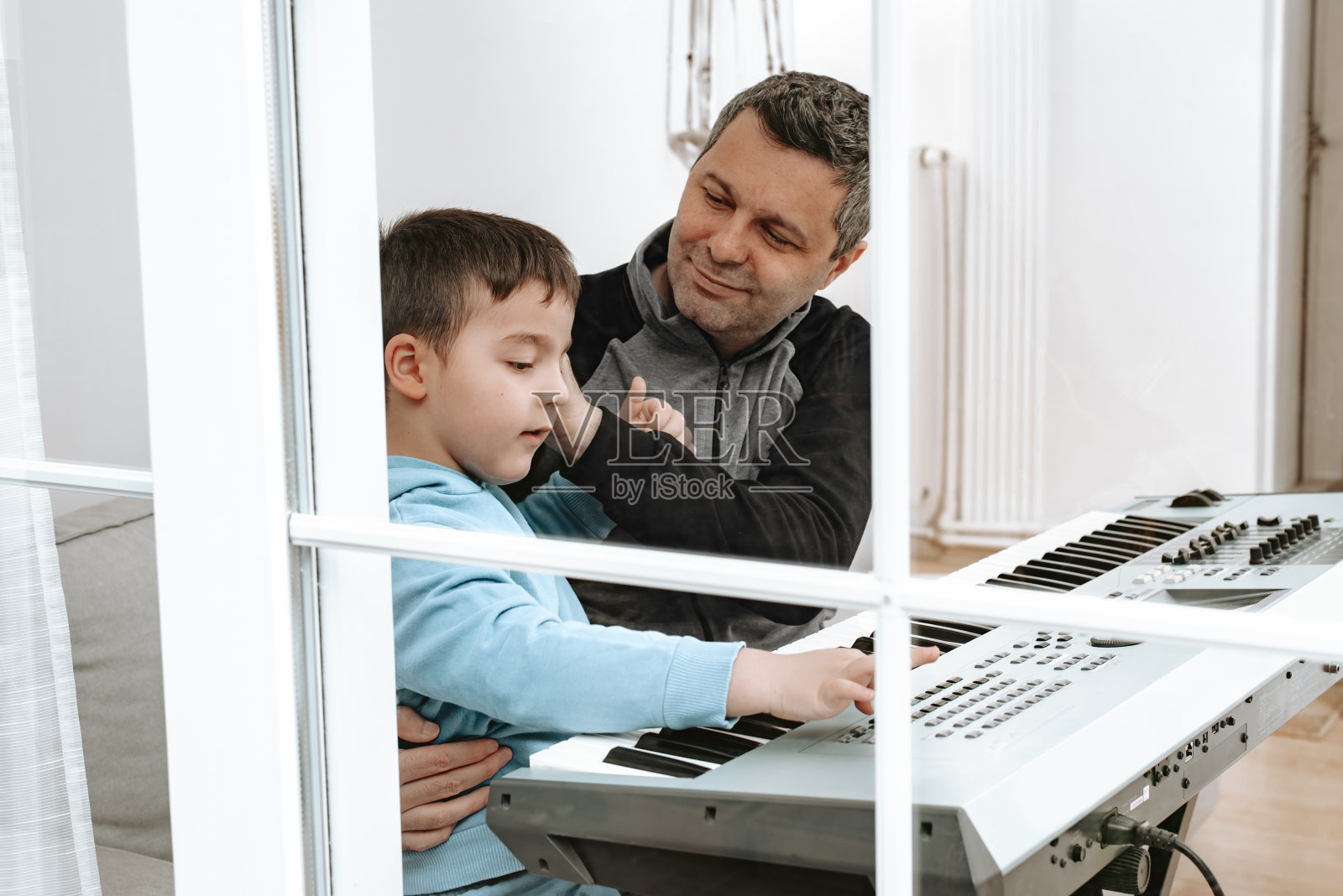 父亲和儿子在家里演奏音乐照片摄影图片