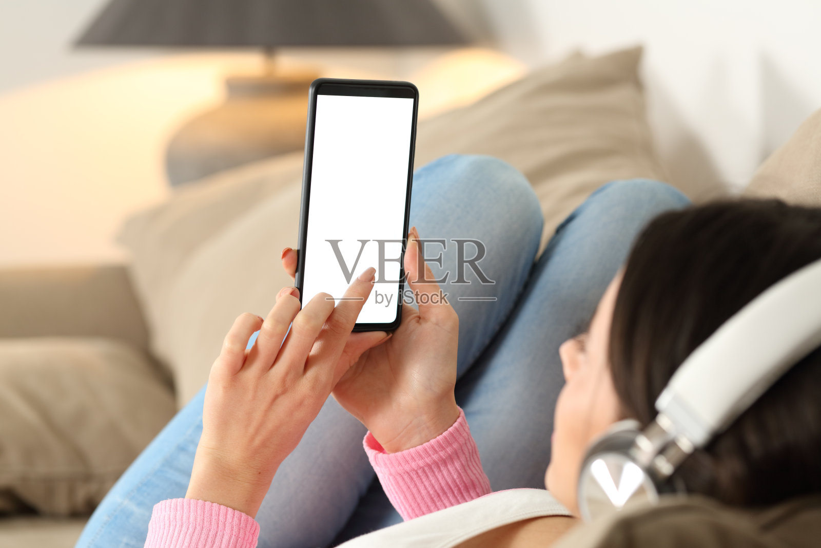 戴着耳机看手机空白屏幕的女人照片摄影图片