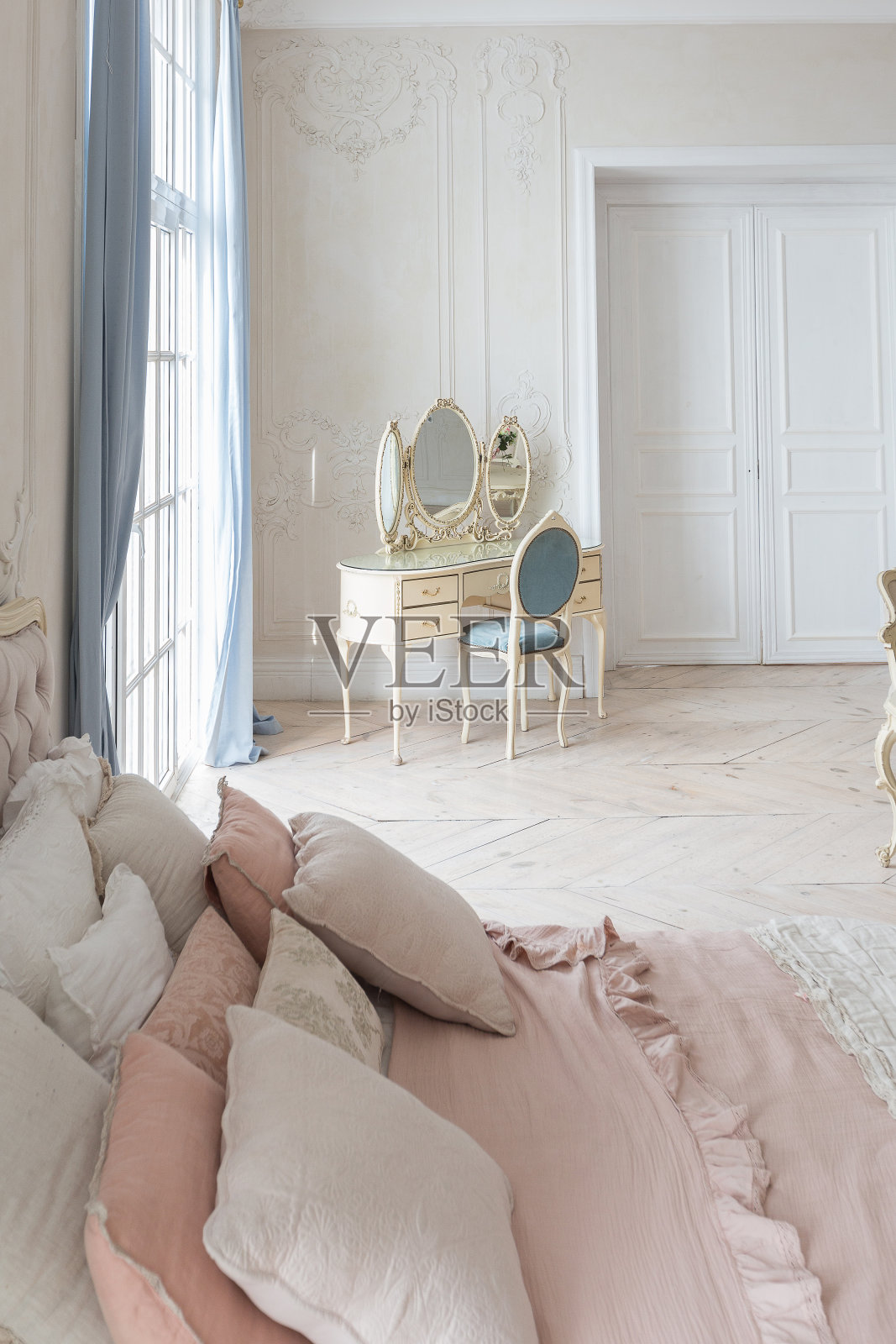 巴洛克风格的豪华灯光内部。宽敞的房间里有别致漂亮的家具，有壁炉和鲜花。墙壁上用植物灰泥和轻木地板装饰照片摄影图片