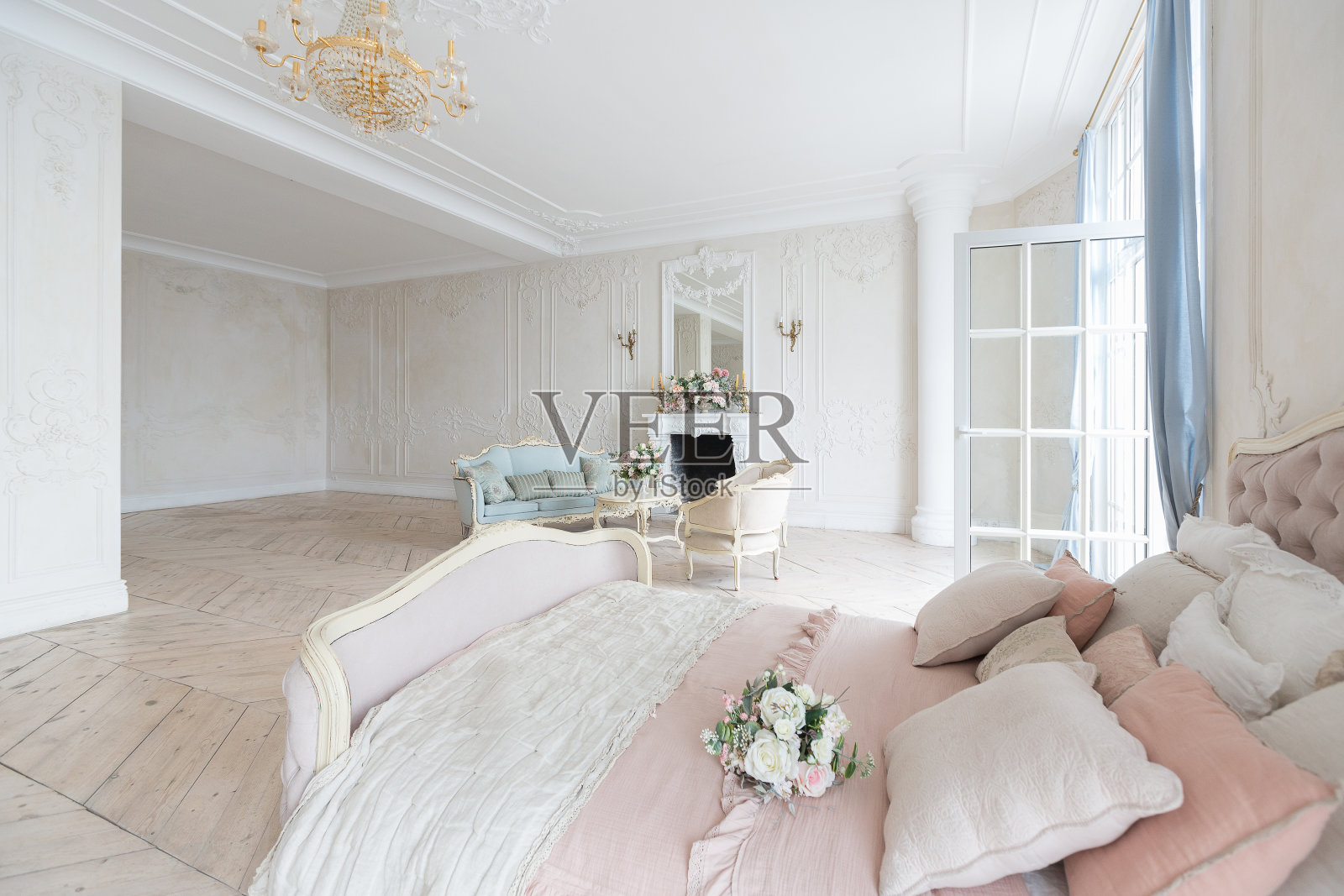 巴洛克风格的豪华灯光内部。宽敞的房间里有别致漂亮的家具，有壁炉和鲜花。墙壁上用植物灰泥和轻木地板装饰照片摄影图片