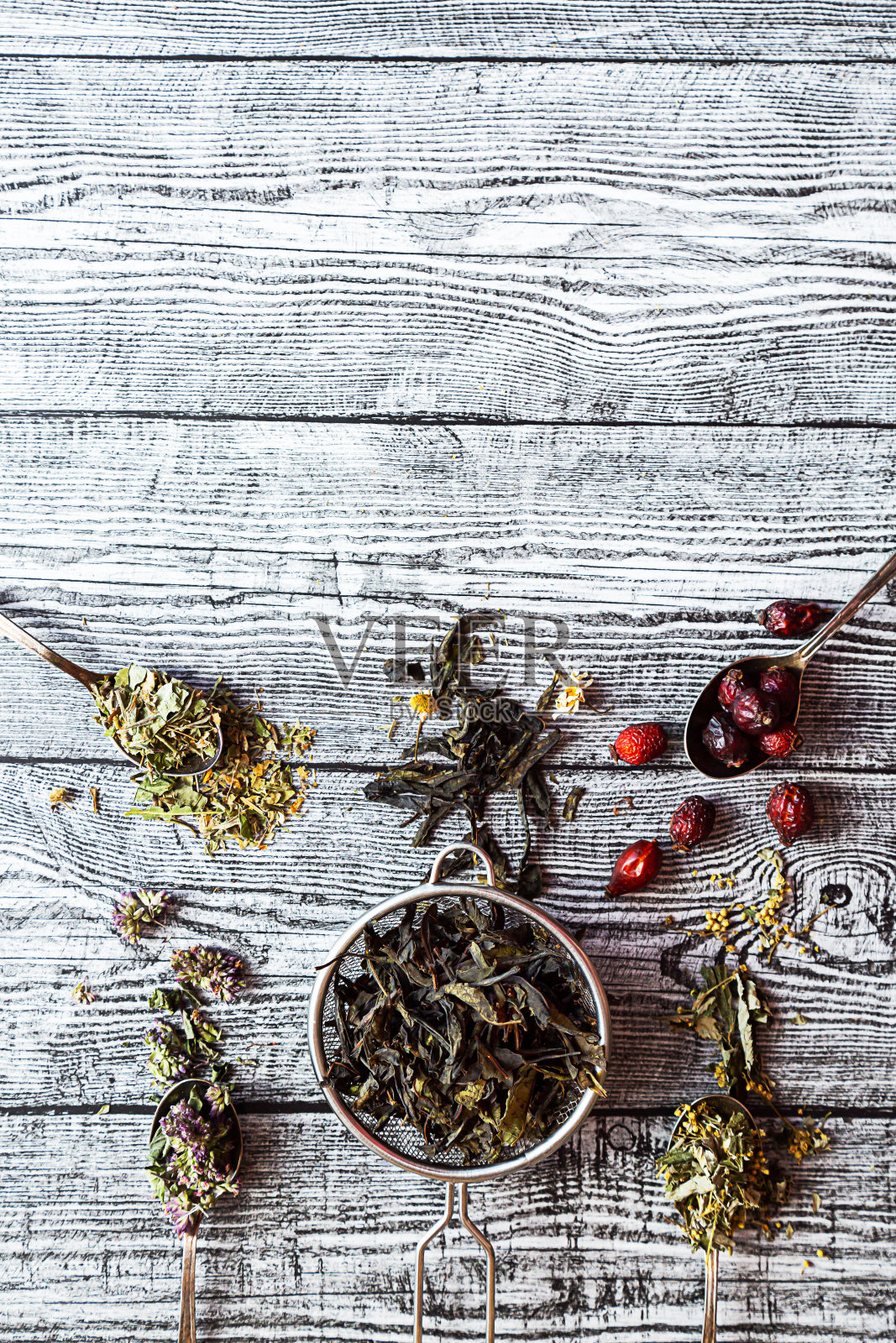 各类花草茶。Chamaenerion，洋甘菊，玫瑰果，Origanum和Filipendula在灰色木桌与复印空间。天然草药照片摄影图片