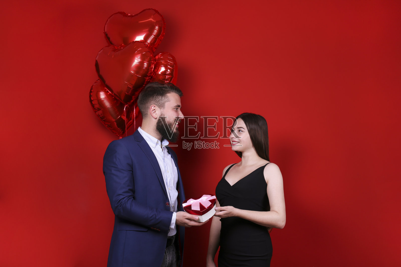 年轻漂亮的夫妇在工作室摆姿势。照片摄影图片