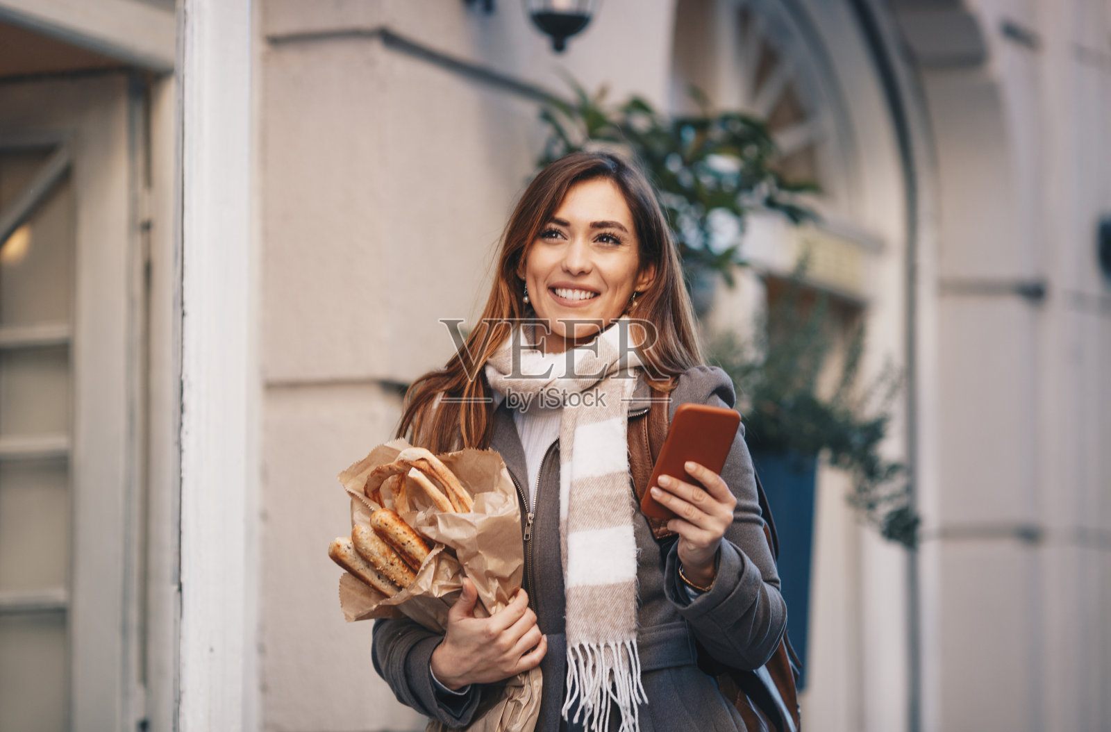 女人发短信，拿着烘焙产品。照片摄影图片