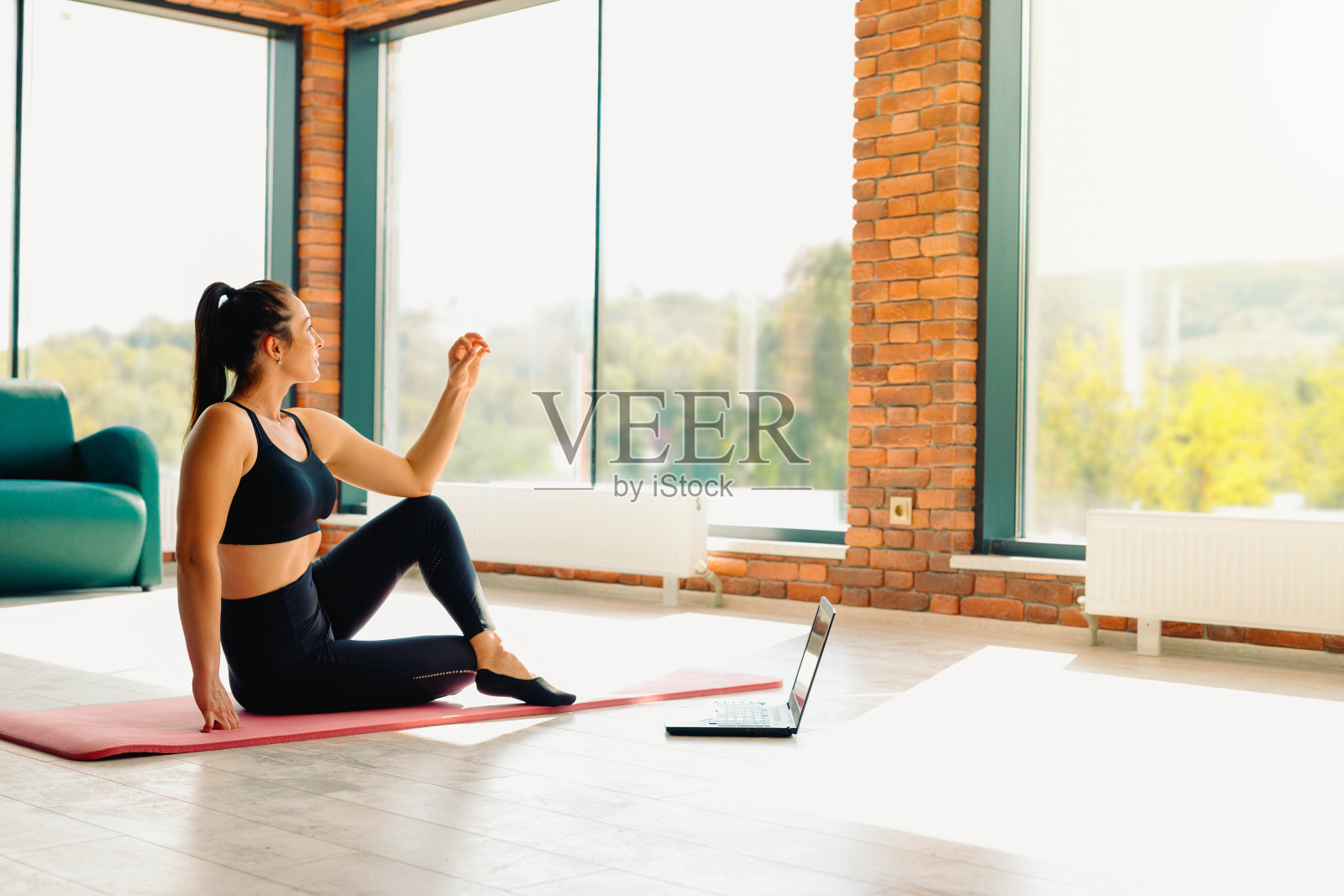 瑜伽教练。一个运动女性与一个美丽的体形参与一个在线视频锻炼。冥想，一种健康的生活方式，一种新的正常观念。照片与空白的边空间照片摄影图片