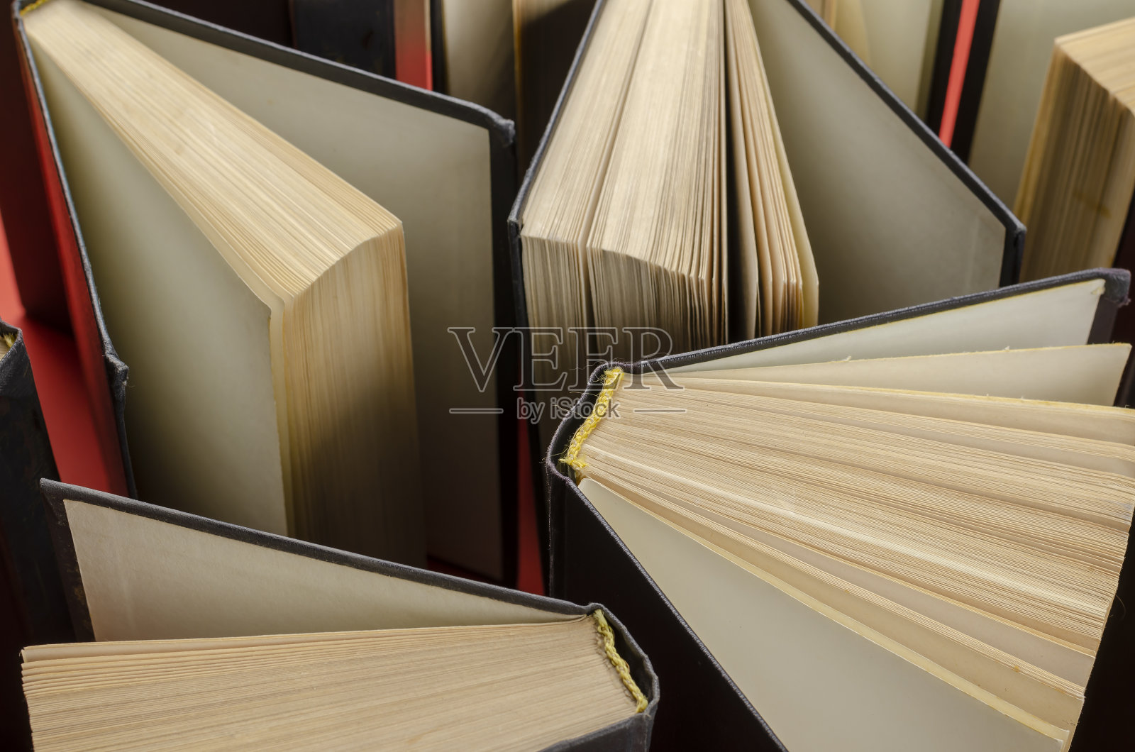 用红色背景上的旧精装书组成。照片摄影图片