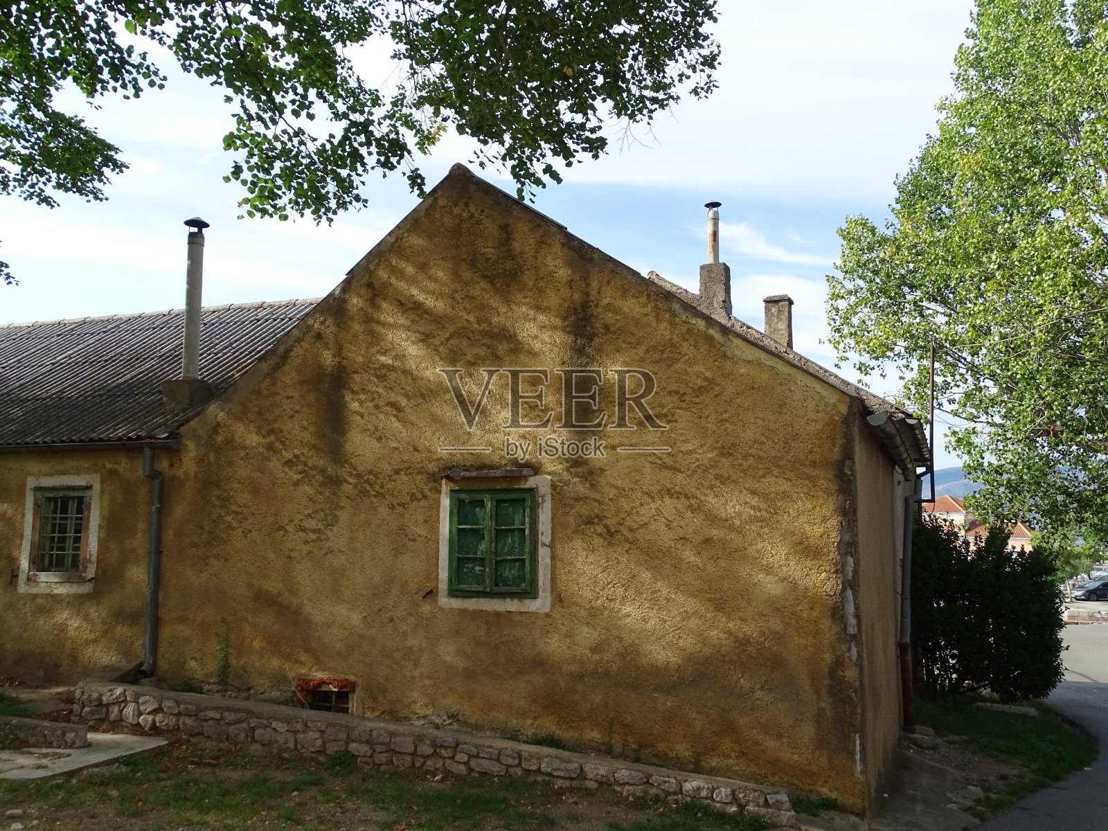 夏天，在克罗地亚海边，可以看到带有折叠百叶窗屋顶的老房子照片摄影图片