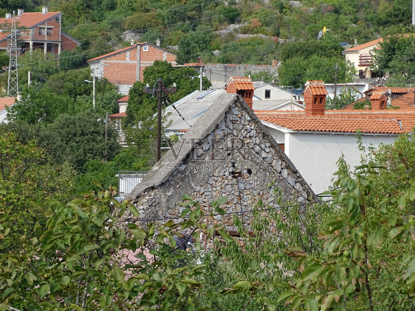 夏天，在克罗地亚海边，可以看到带有折叠百叶窗屋顶的老房子照片摄影图片
