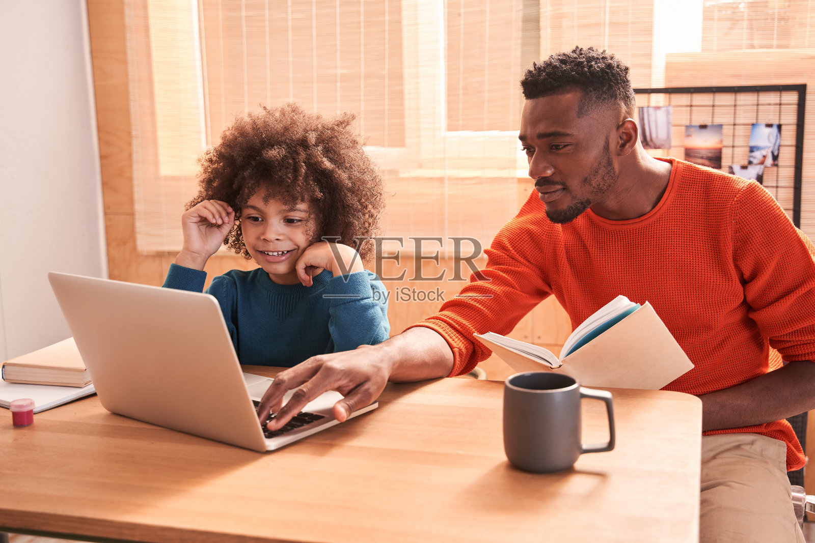 男孩喜欢在家里和愉快的爸爸一起学习照片摄影图片