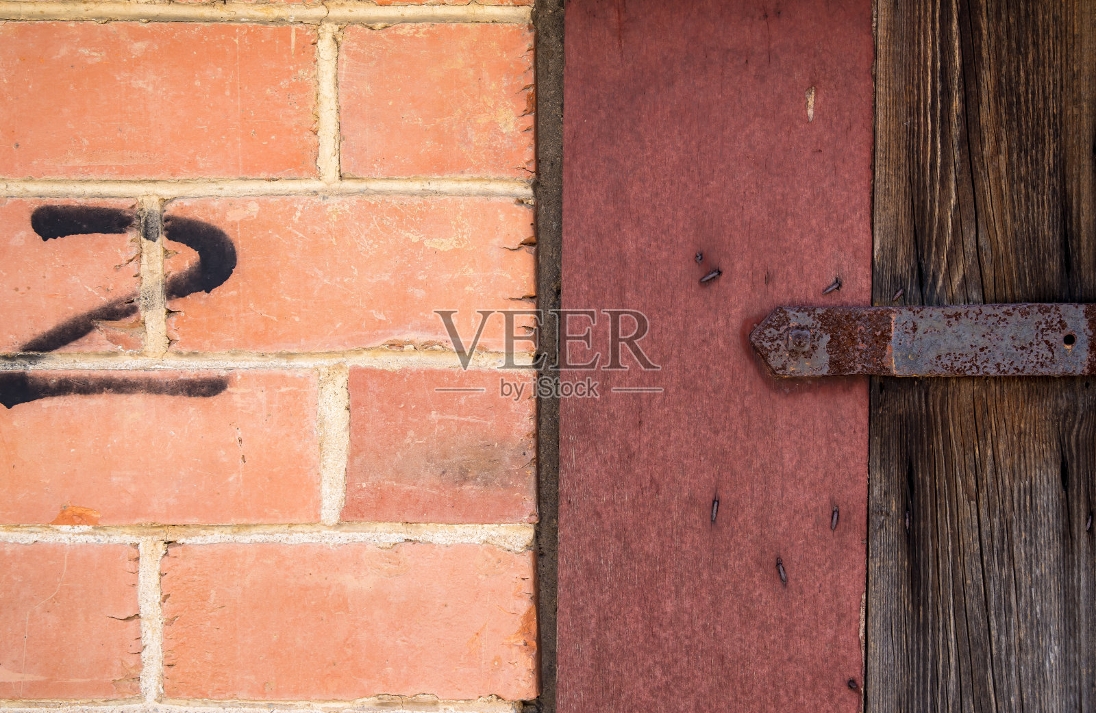 靠近一堵砖墙，上面有一扇木门的细节照片摄影图片