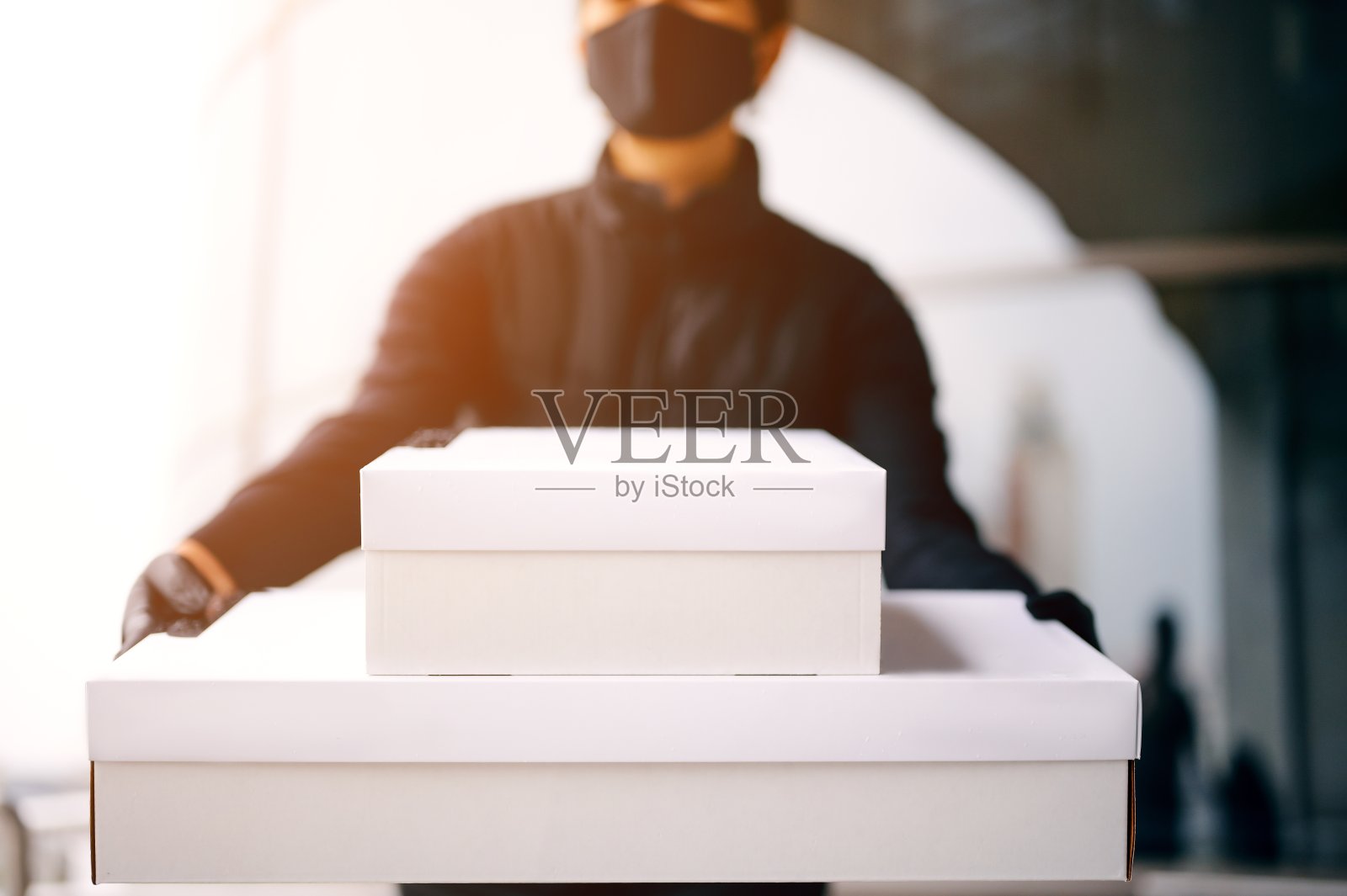 健康保护、安全和流行病概念——带口罩和手套的妇女手持纸箱在户外接生照片摄影图片