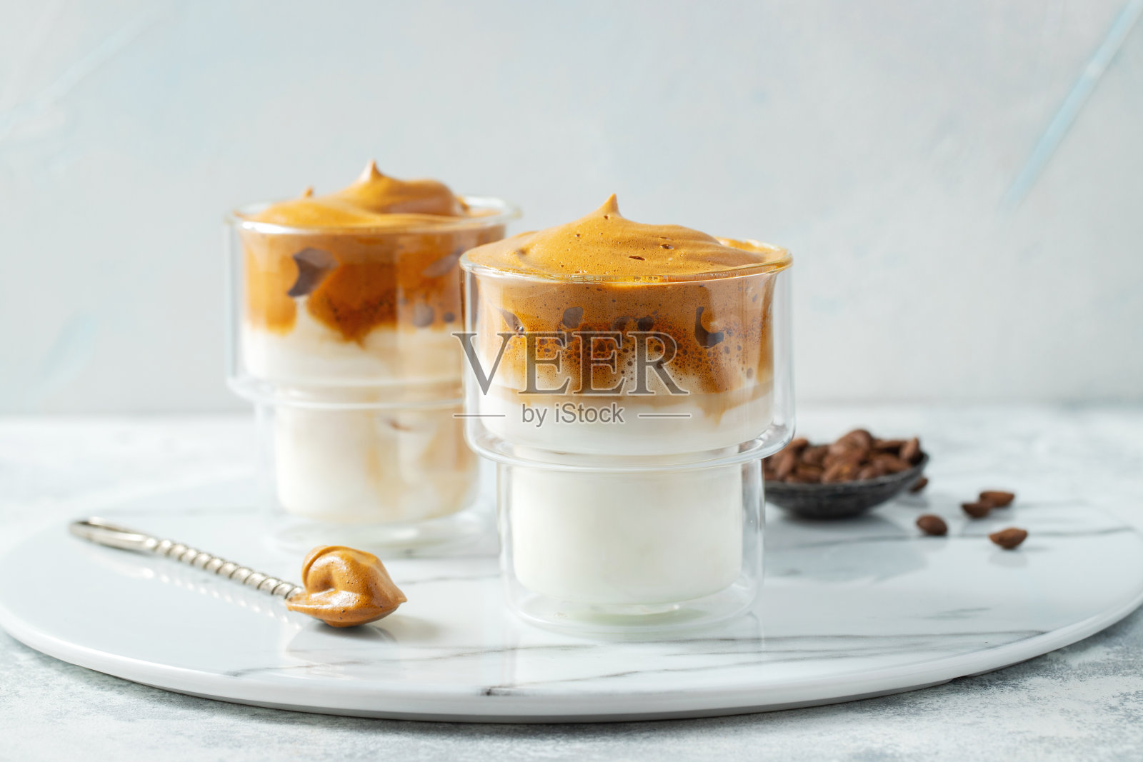 Dalgona咖啡。冰，蓬松，奶油，混合咖啡泡沫和牛奶。时兴饮品2019冠状病毒病期间城市封锁和自我隔离，待在家里的理念照片摄影图片