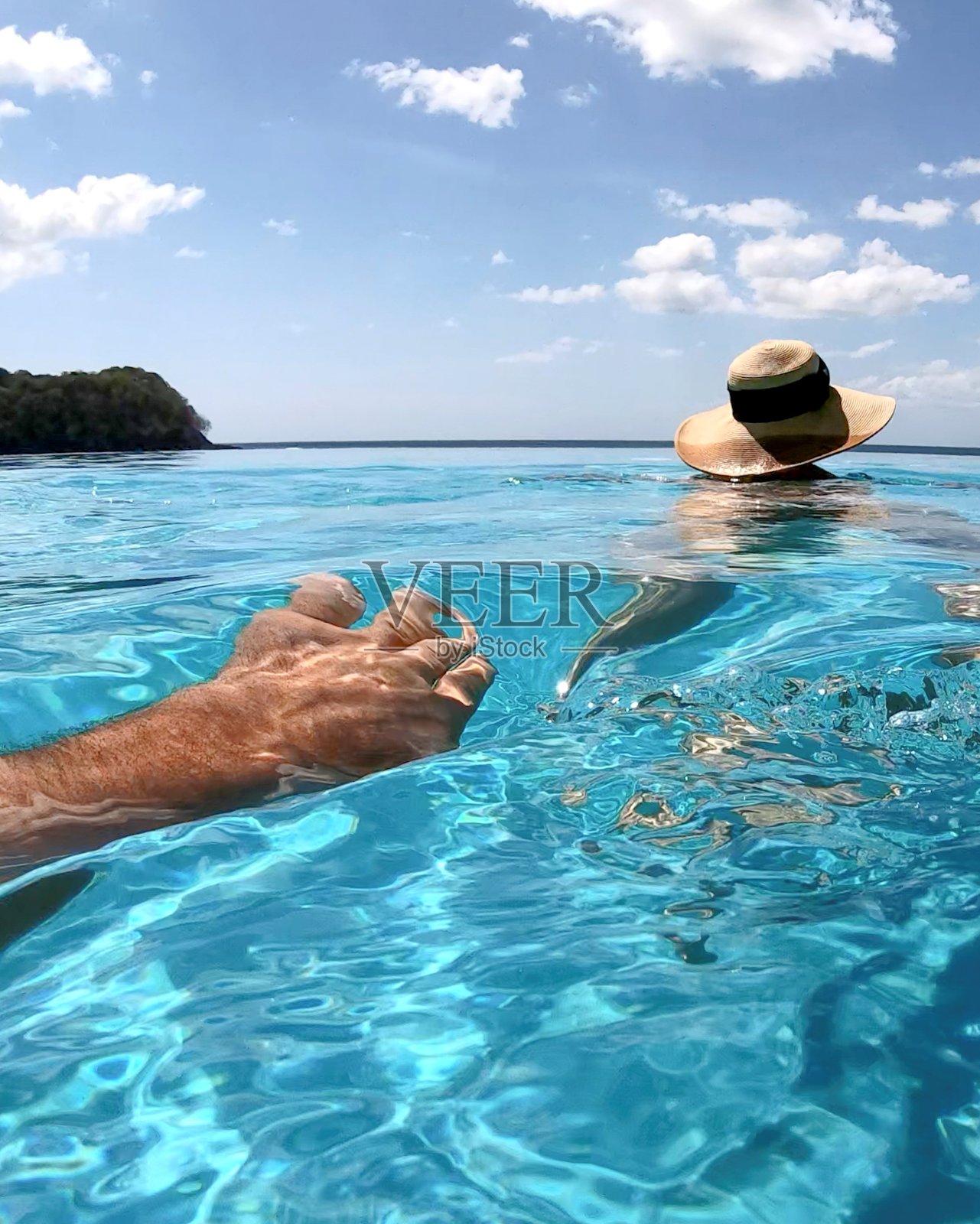 清晨，男子游过游泳池，向女子游去照片摄影图片
