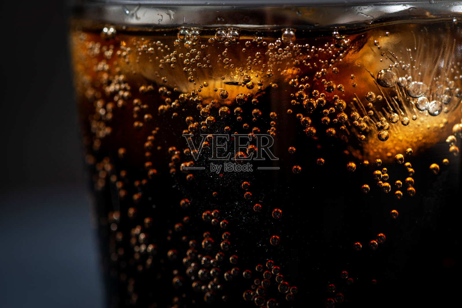 一杯可口可乐与冰在一个黑色的背景，特写照片摄影图片