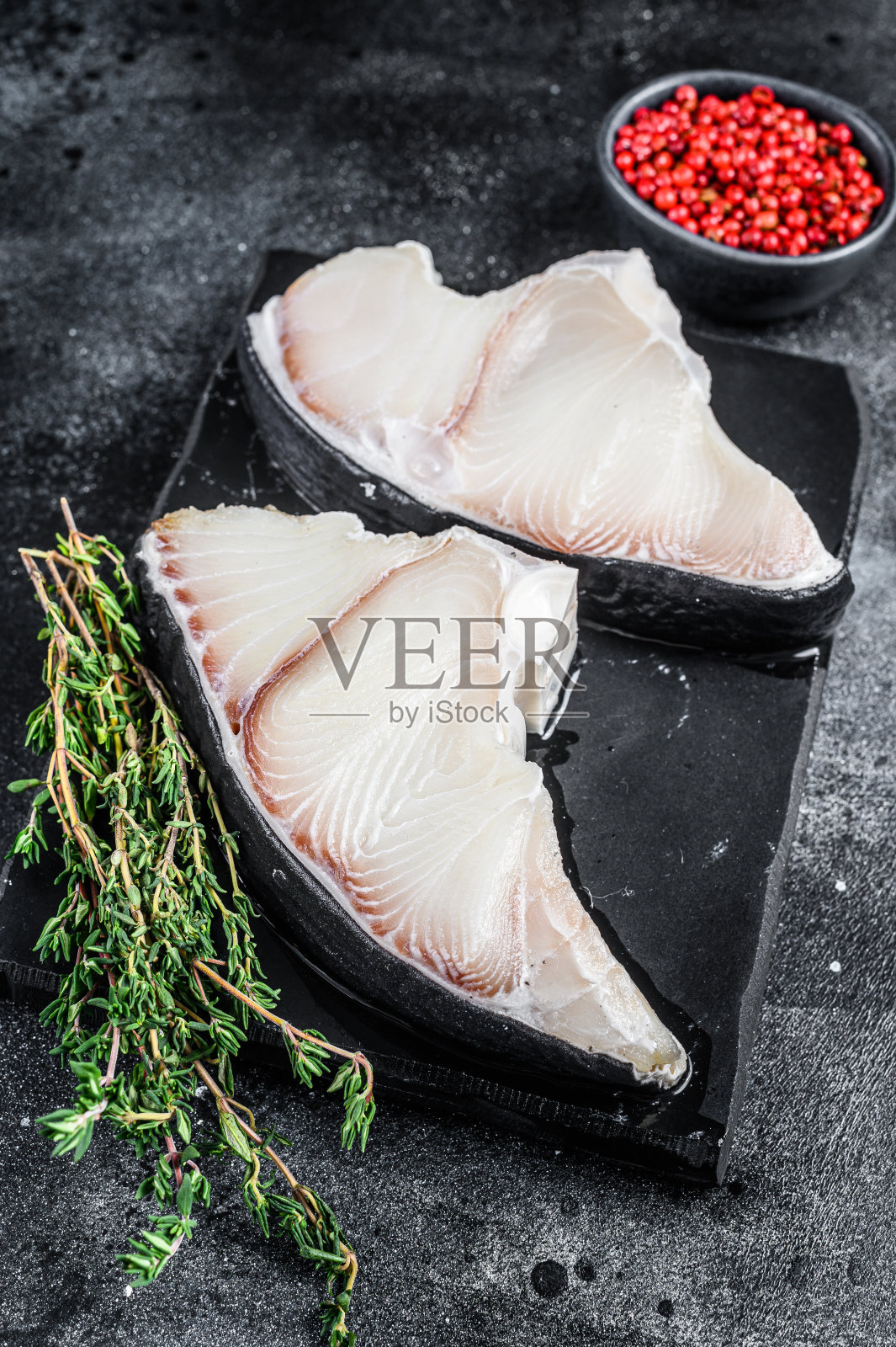 一块板上的生鲨鱼鱼排。黑色背景。俯视图照片摄影图片