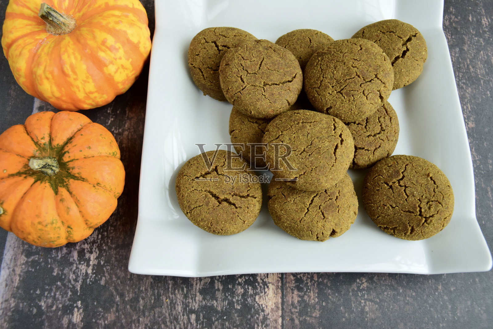 木制背景上放南瓜饼干，旁边放南瓜照片摄影图片