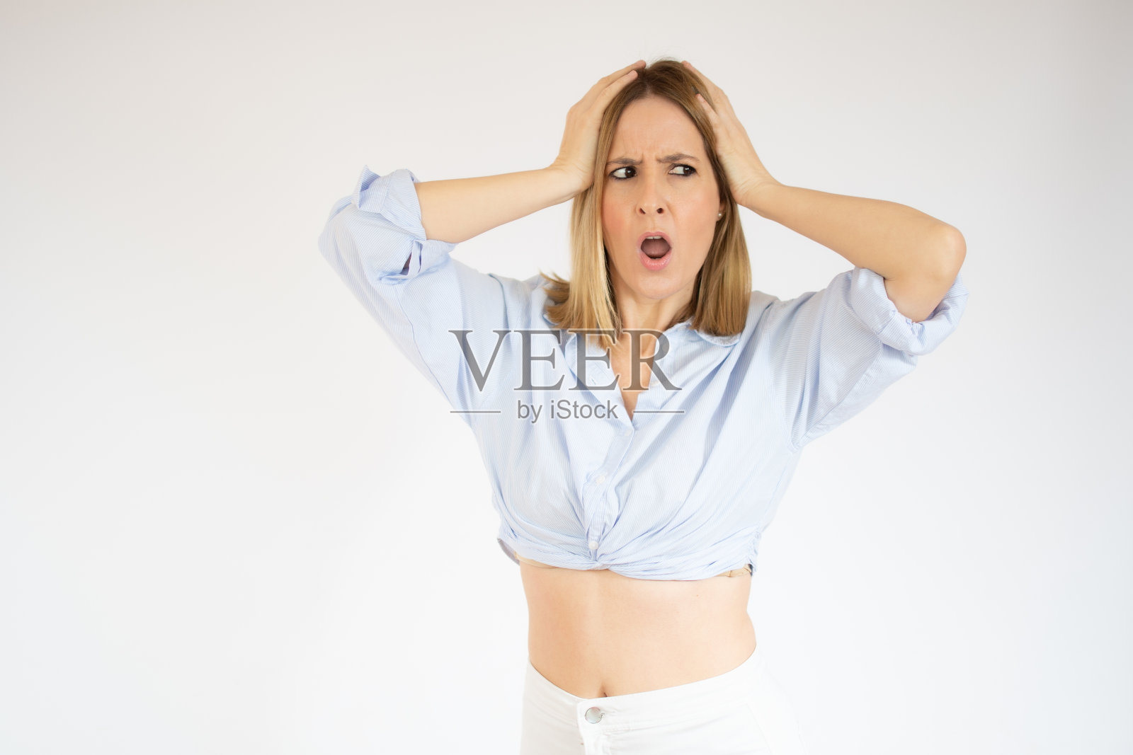 年轻的金发女人感到恐惧和震惊的白色背景。照片摄影图片