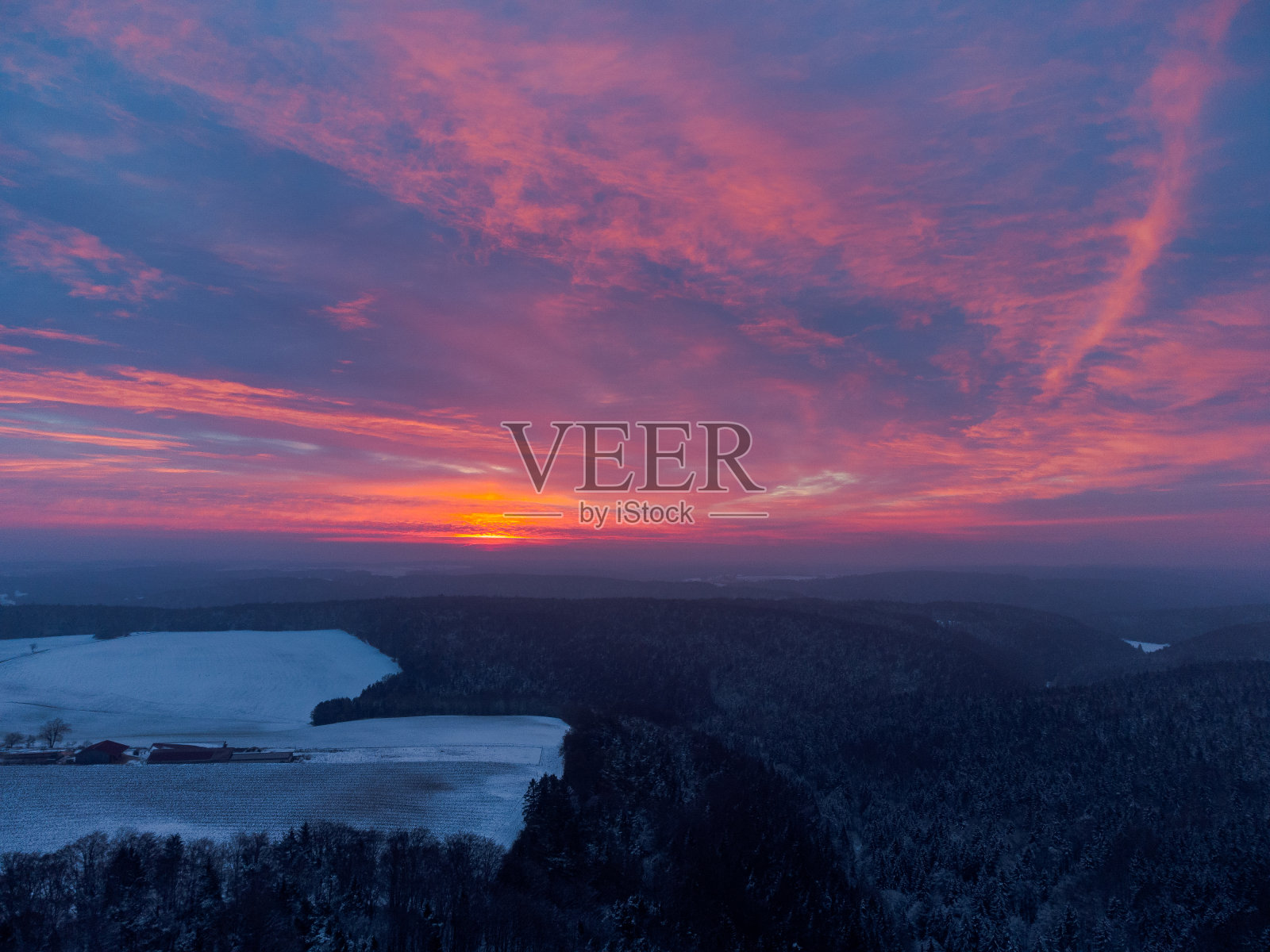 无人机的惊人的红色日出背后的云巴伐利亚森林和田野地区与雪在冬天的全景照片摄影图片