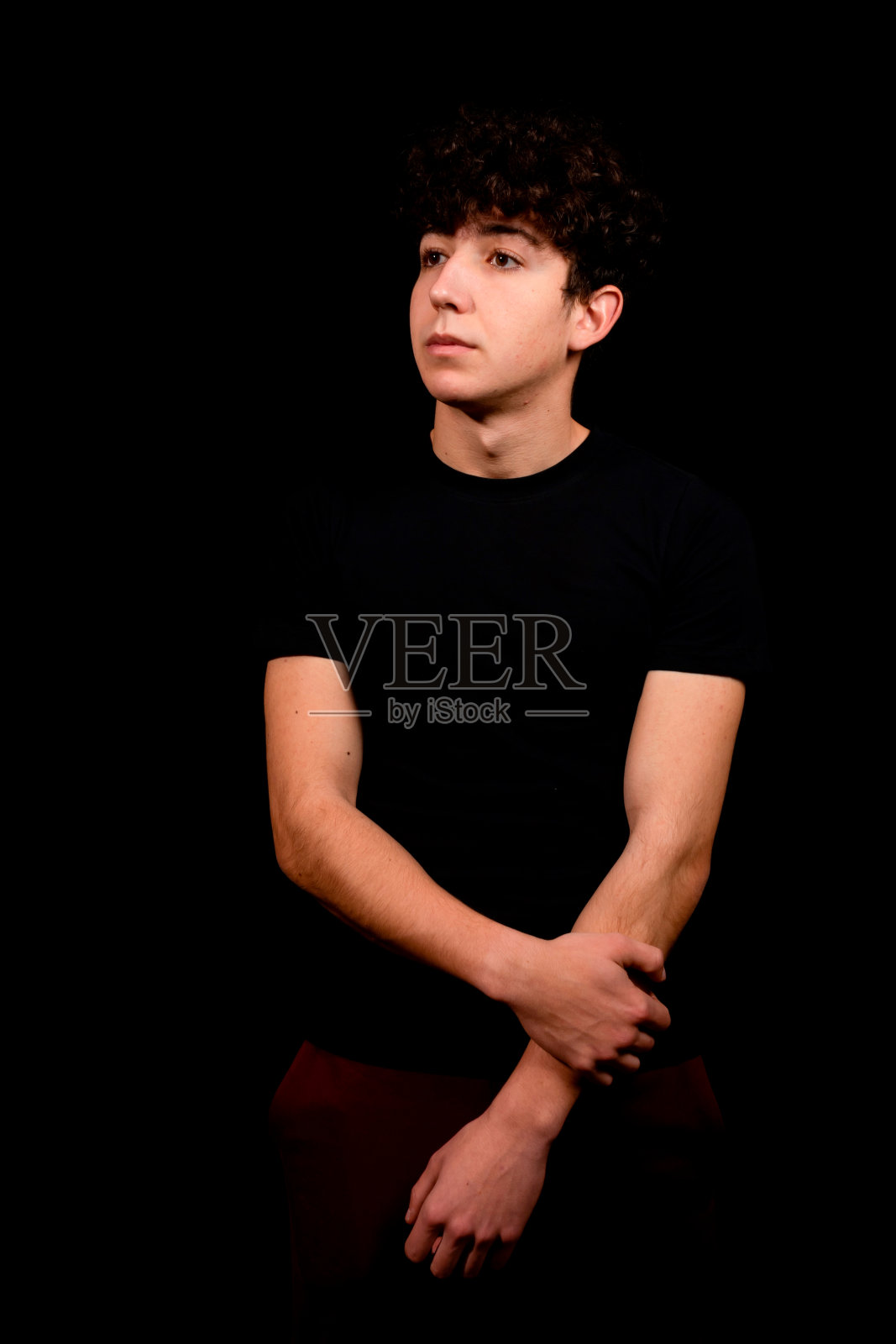 有吸引力的年轻男子与卷发摆姿势的黑色背景照片摄影图片