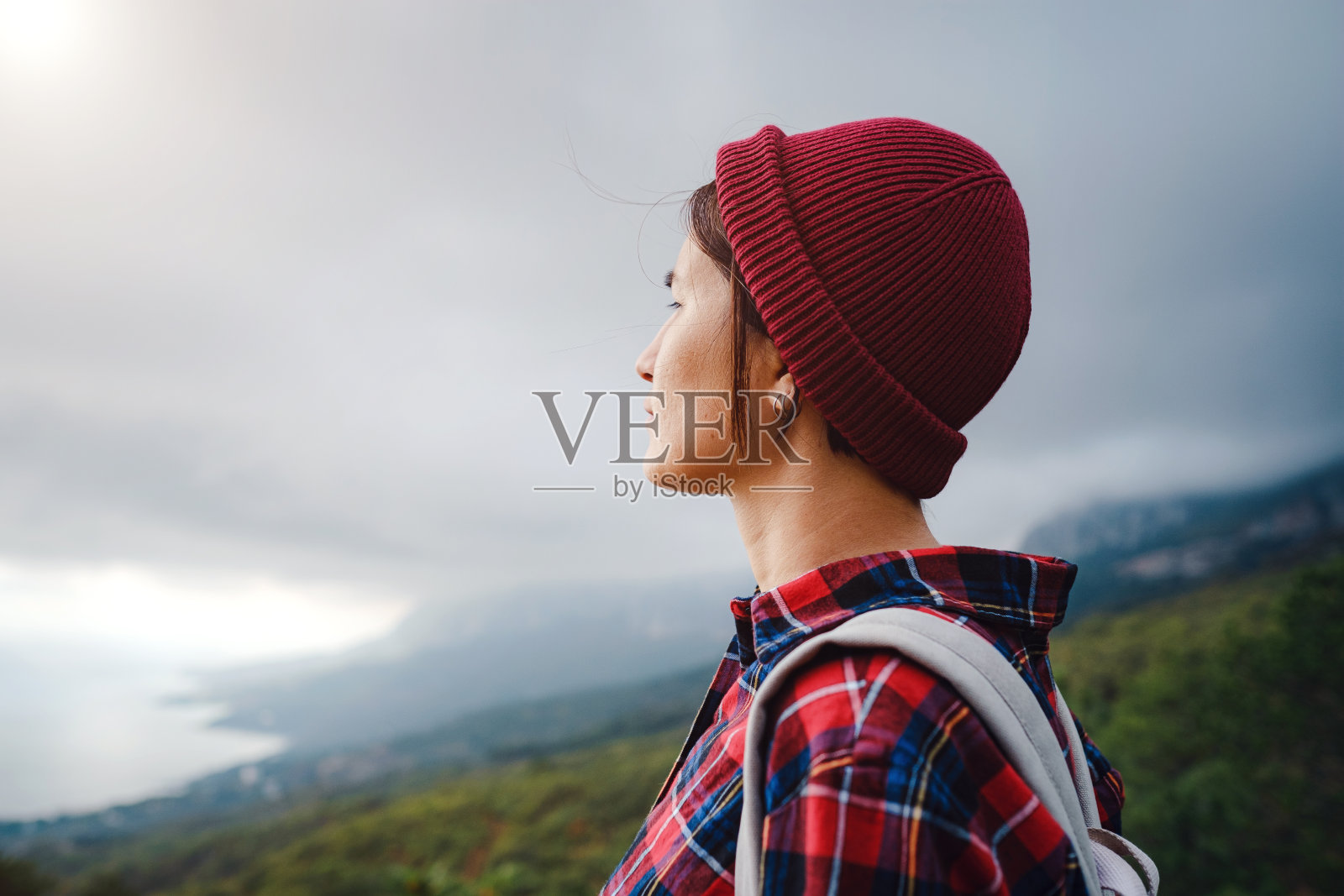 戴着帽子走在山顶的时髦时髦的女人。照片摄影图片