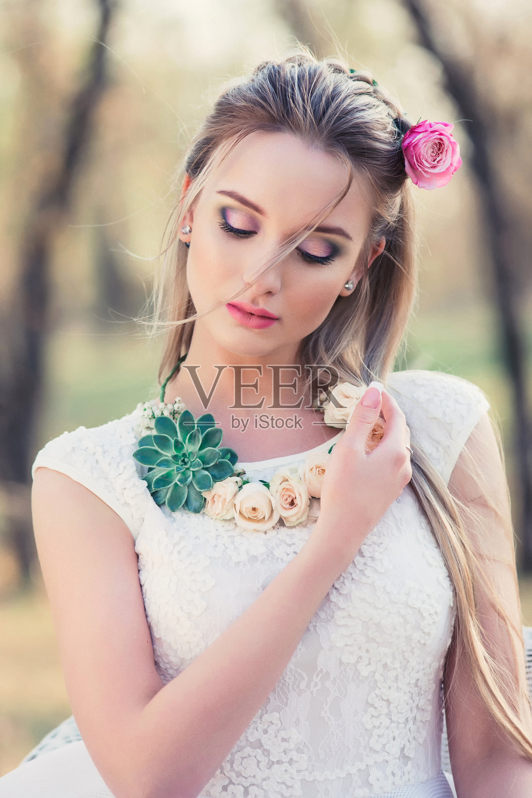 美丽的女人户外肖像与鲜花在春天的自然照片摄影图片