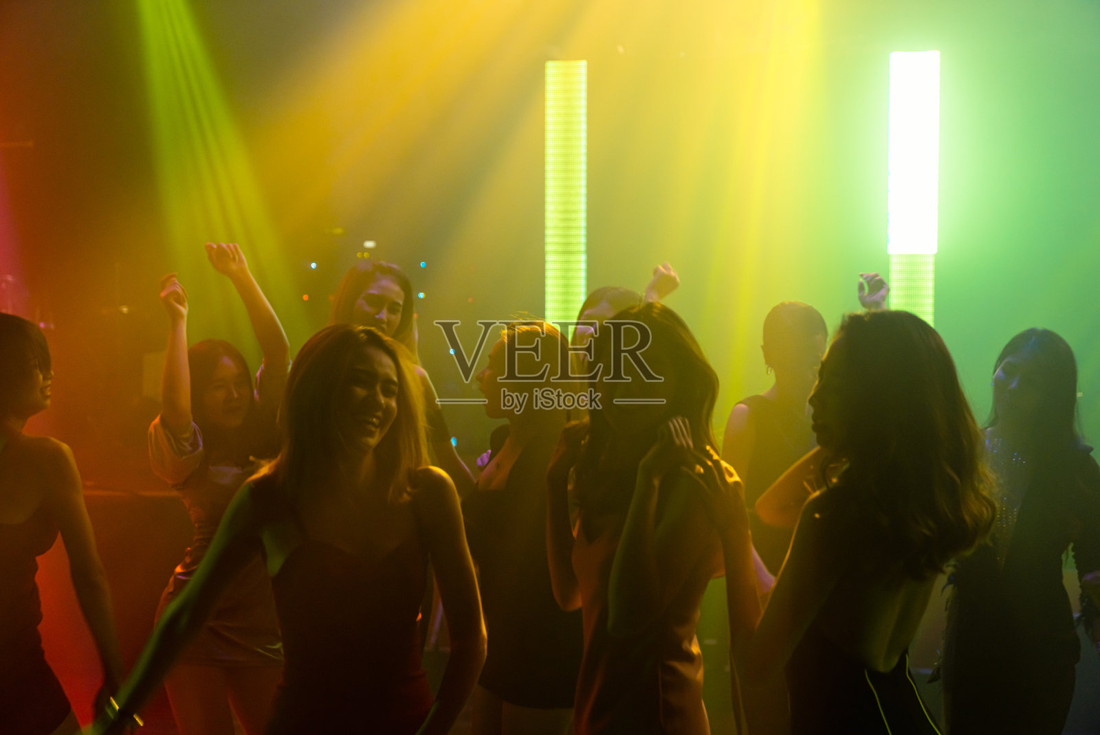 人们在迪斯科夜总会随着DJ的音乐在舞台上跳舞的剪影照片摄影图片
