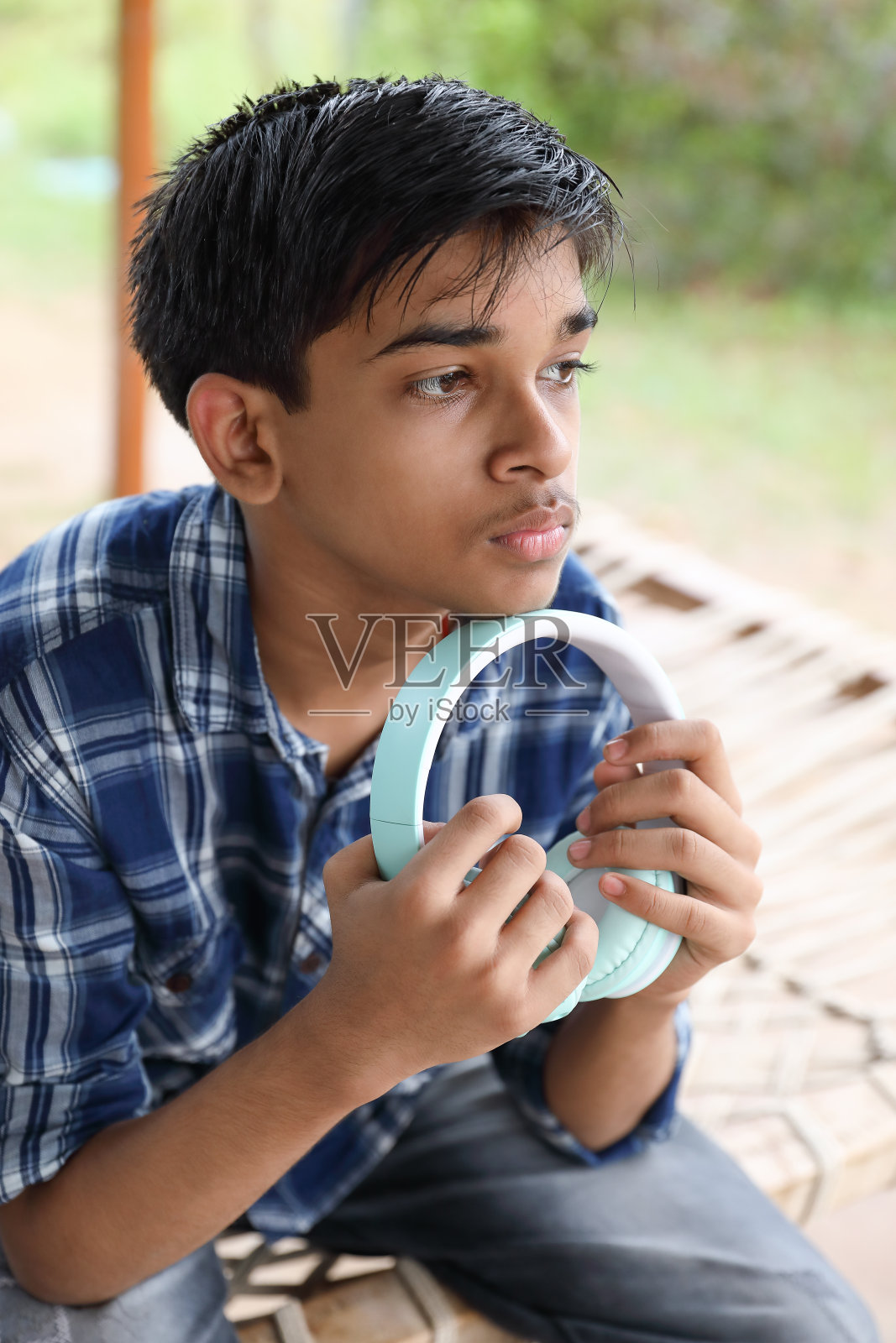 印度小男孩戴着耳机听音乐的肖像照片摄影图片