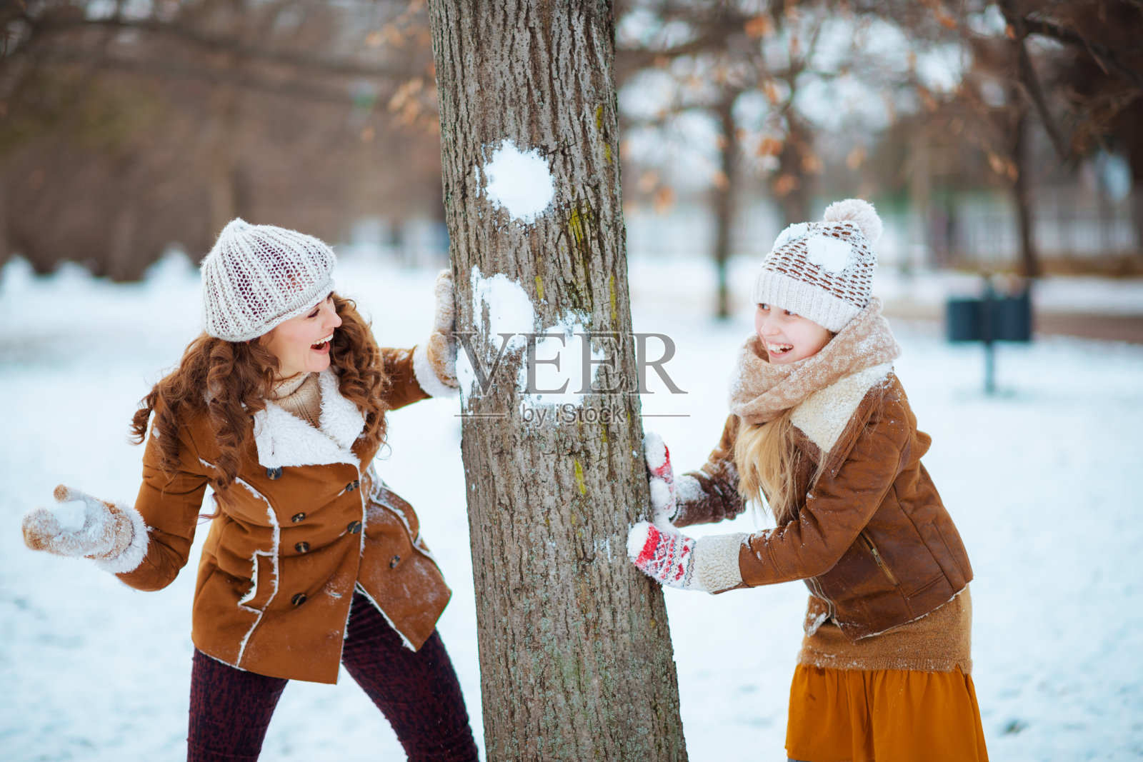 快乐的现代妈妈和孩子玩雪球照片摄影图片