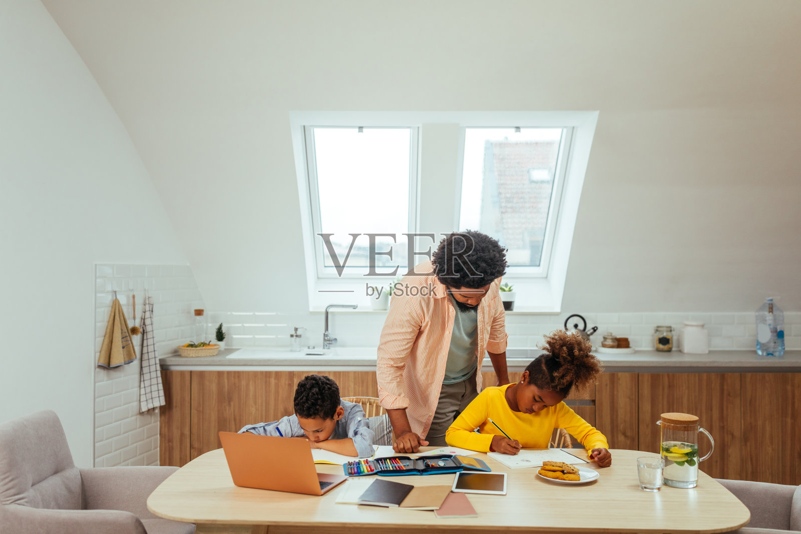 父亲帮助孩子们做家庭作业照片摄影图片