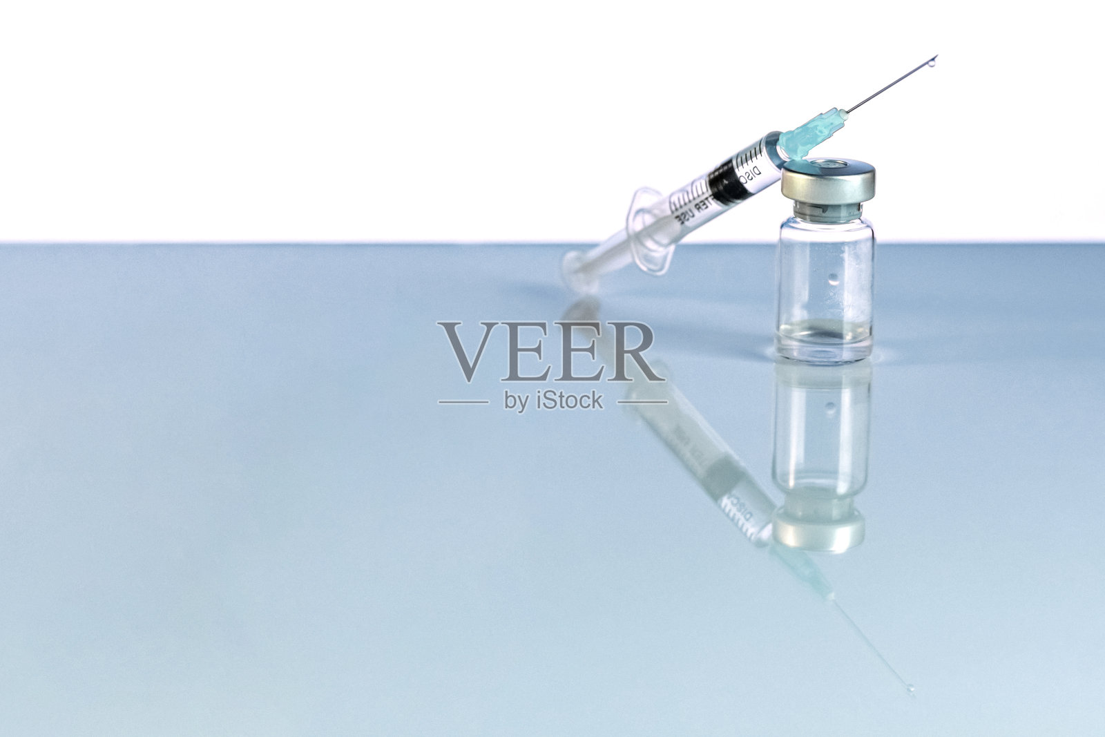 装有冠状病毒疫苗的注射器和小瓶，注射小瓶剂量在蓝色背景上。预防、医学概念、covid-19免疫接种。照片摄影图片