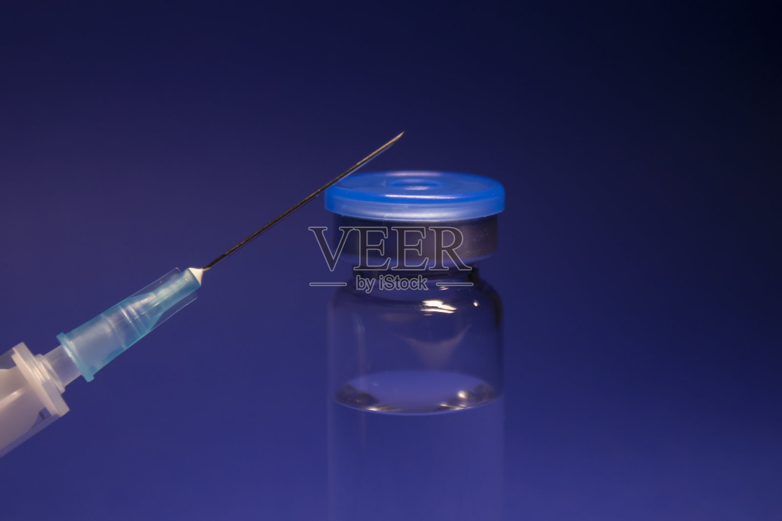 无标签疫苗瓶、医用注射器、注射针。孤立在蓝色背景。COVID-19冠状病毒疫苗的开发。治疗。世界研究竞赛照片摄影图片