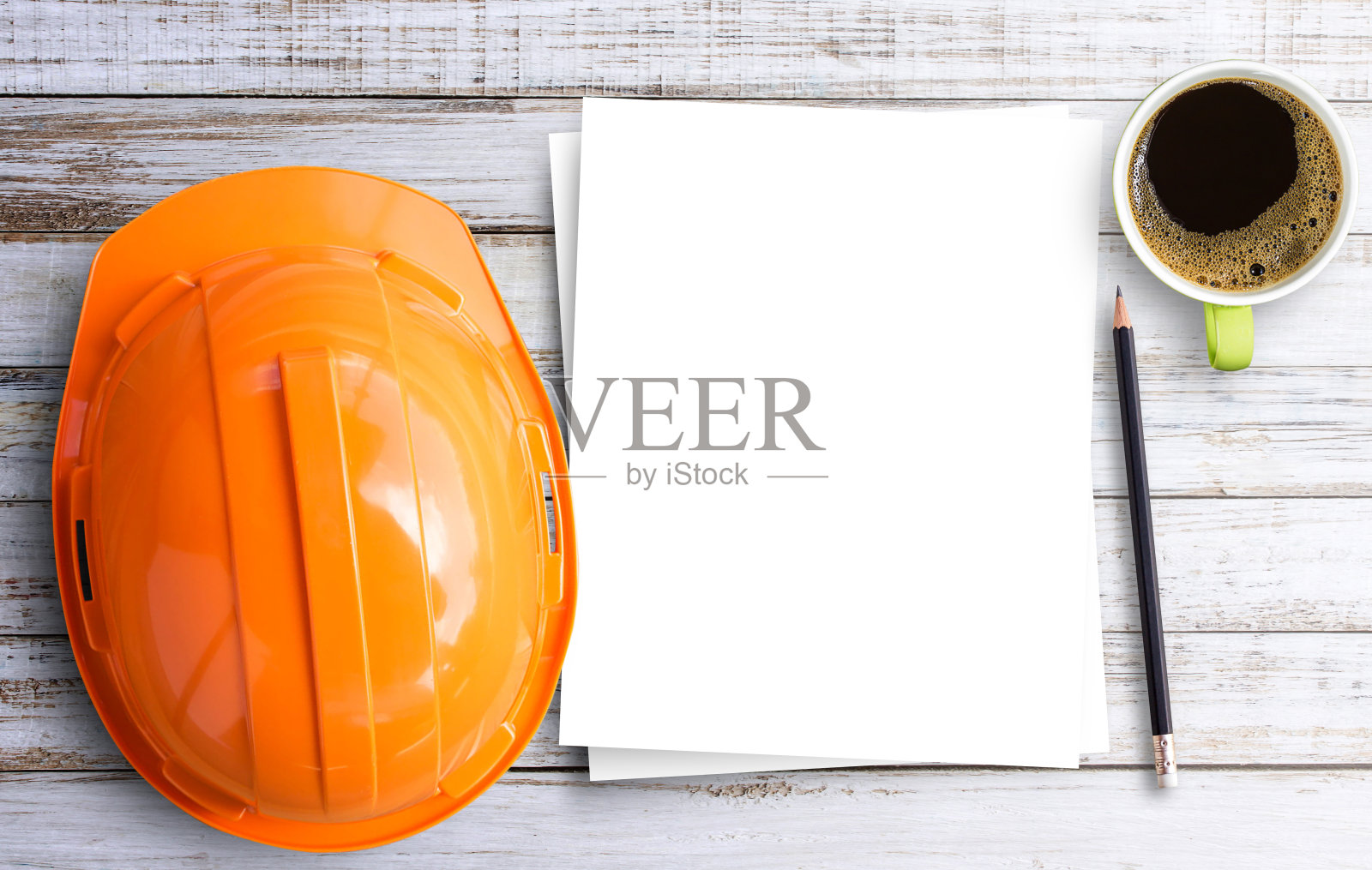 俯视图安全工程师头盔，咖啡杯，铅笔和空白纸在棕色木制桌子的背景。照片摄影图片