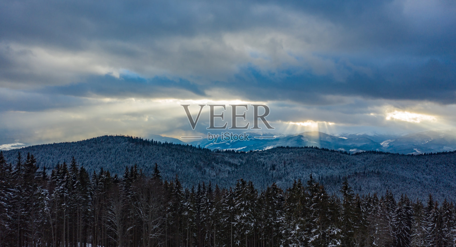 美丽的日落在山上。太阳的光线在云间照耀照片摄影图片