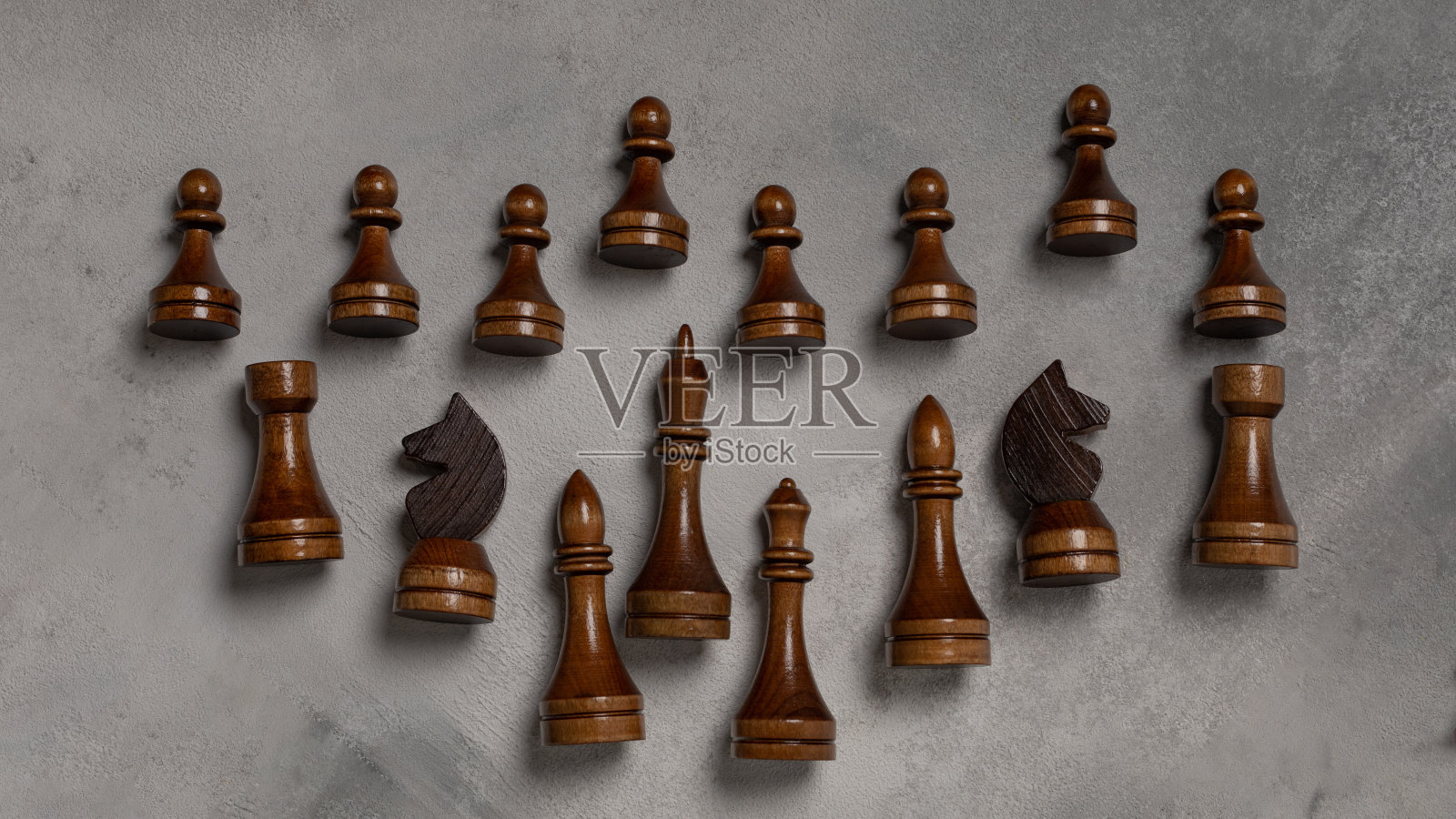 灯光背景下的黑色棋子照片摄影图片