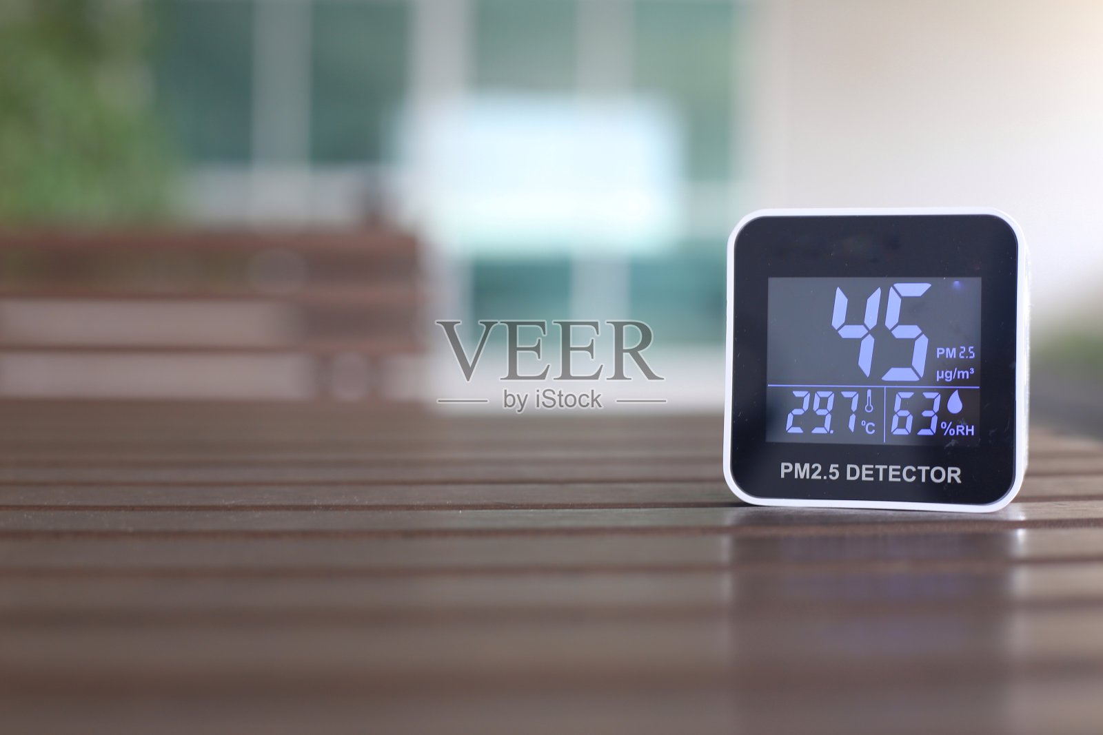 中度高量的2.5微米颗粒物污染空气。传感器检测有害的无形灰尘在空气中。不良的生活条件。移动设备放置在户外的桌子上。照片摄影图片