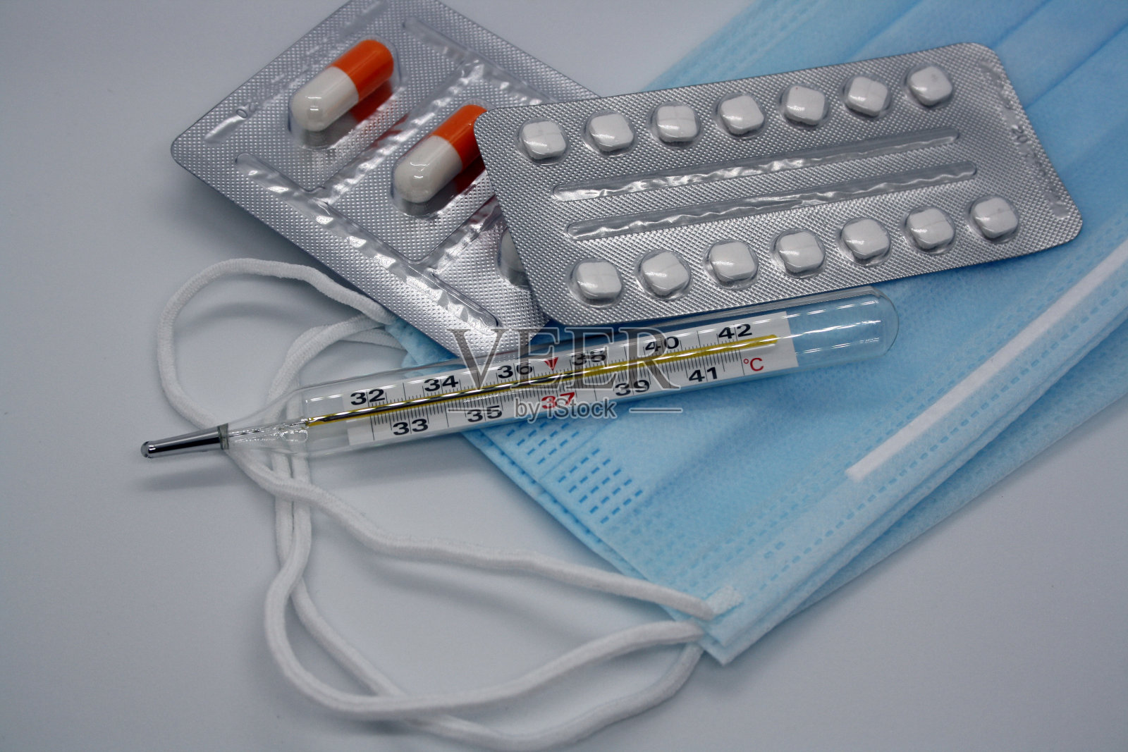 药片，医用口罩和温度计，白色背景。照片摄影图片