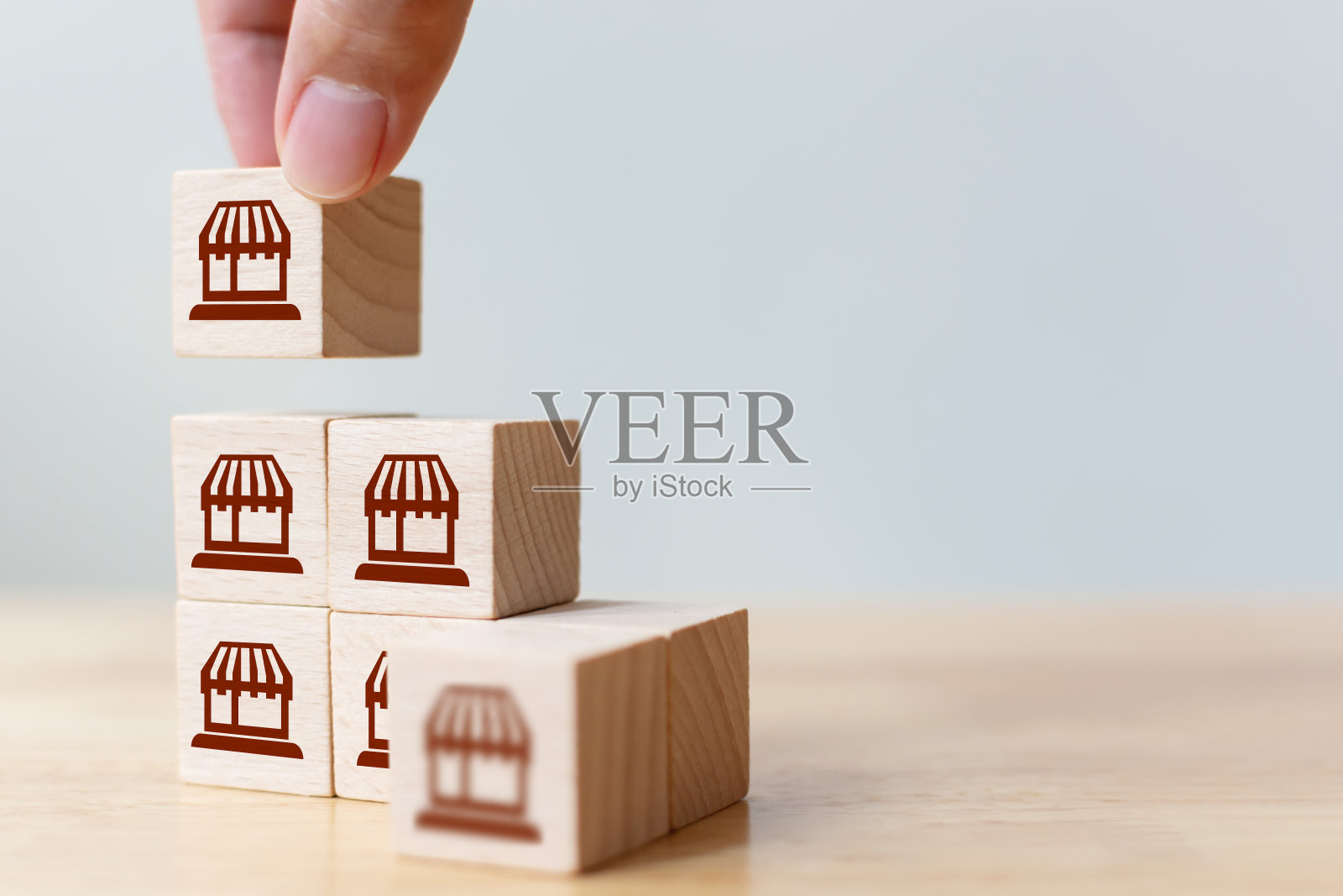 特许经营企业营销体系概念。构建服务商店网络战略。手把木块顶部与图标商店照片摄影图片