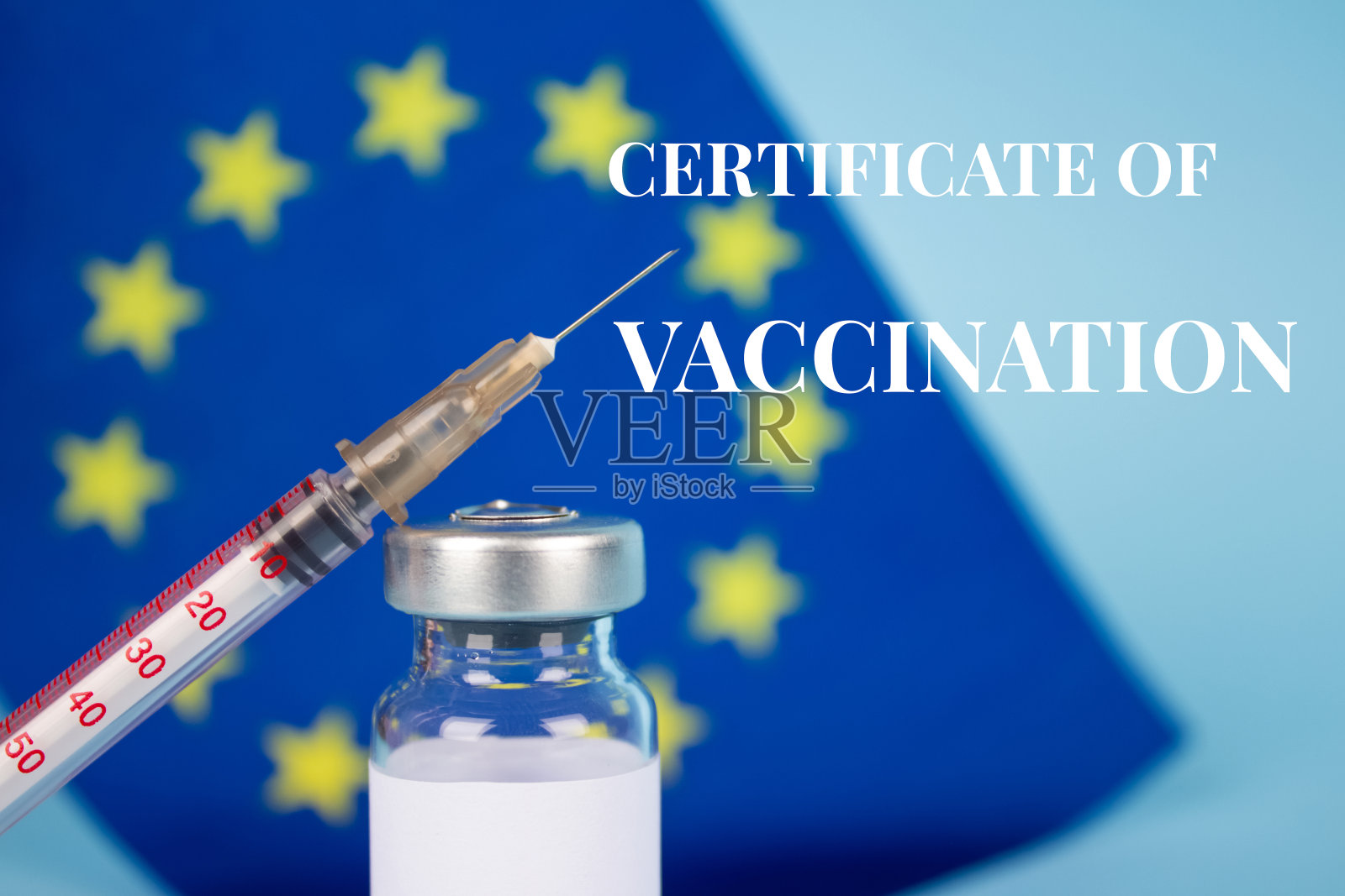 COVID-19疫苗瓶，印有欧盟旗帜，蓝色背景，接种概念数字证书，欧盟疫苗护照。有选择性的重点照片摄影图片