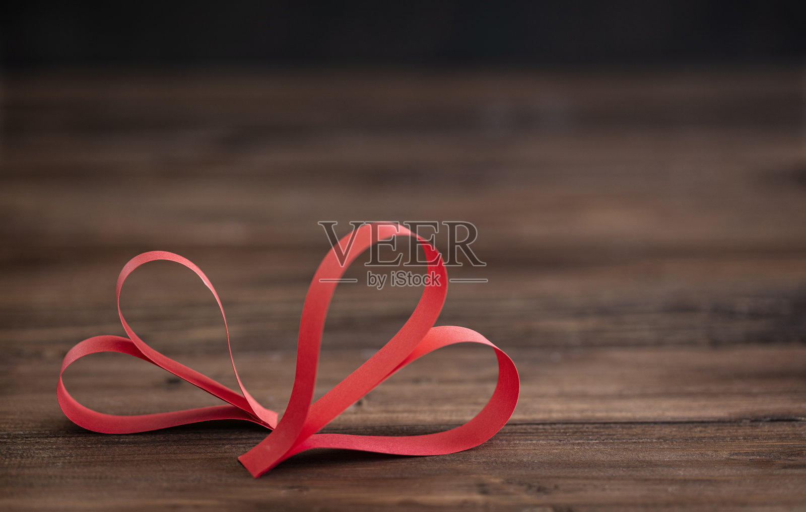 两个手工制作的红心在棕色的木制背景上照片摄影图片