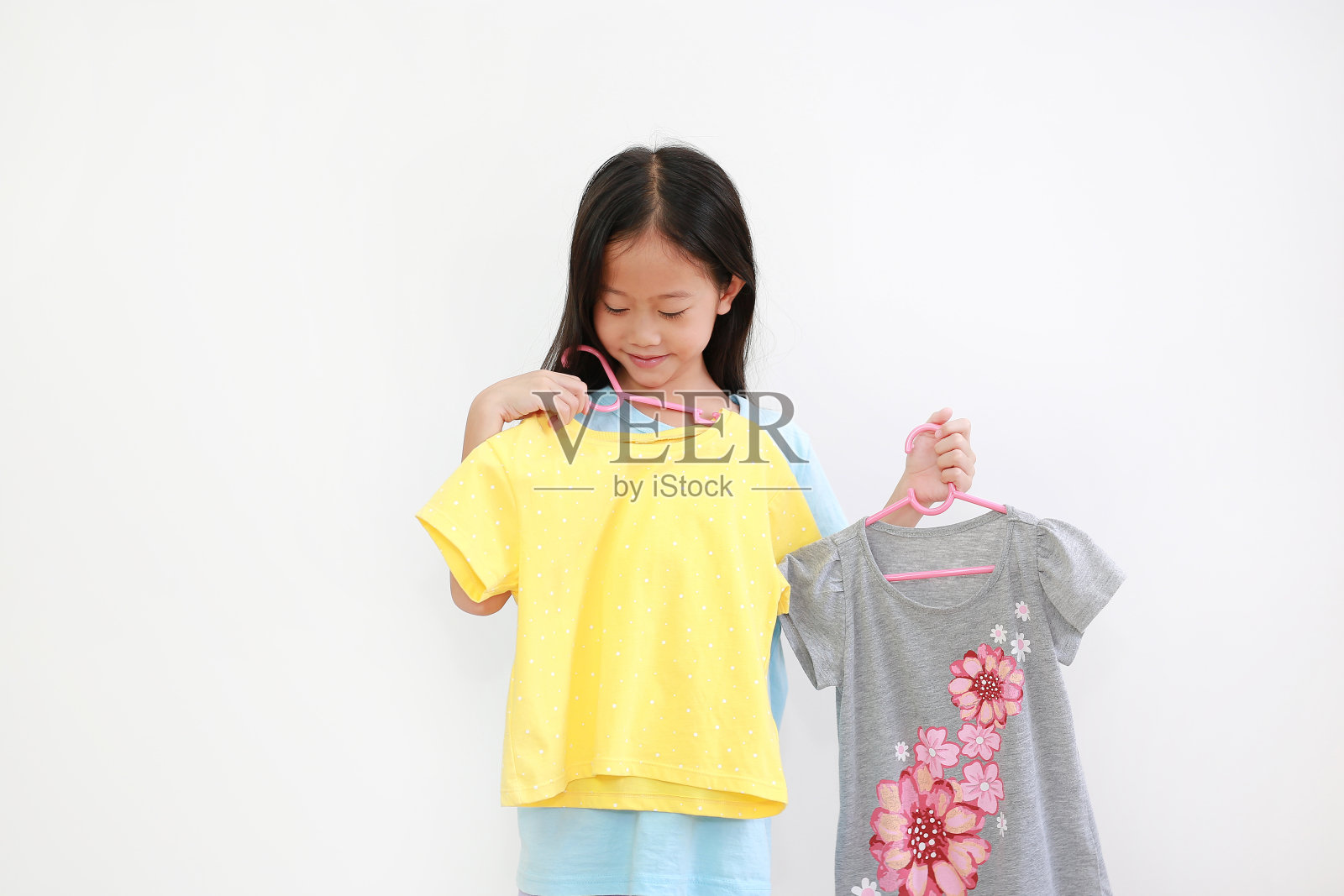 亚洲小孩选择衣服的白色背景照片摄影图片