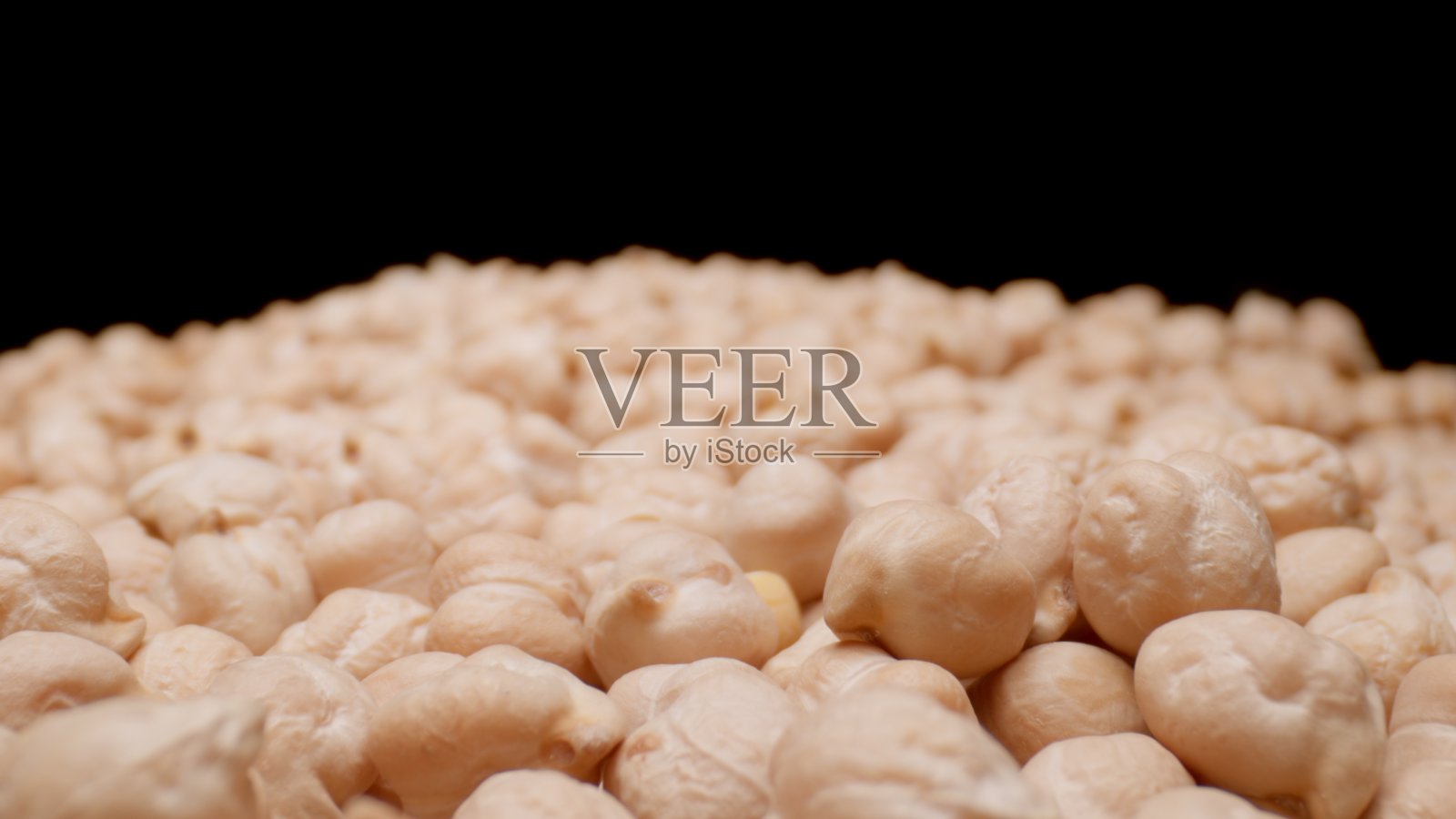 干鹰嘴豆粒。健康食品。黑色背景照片摄影图片