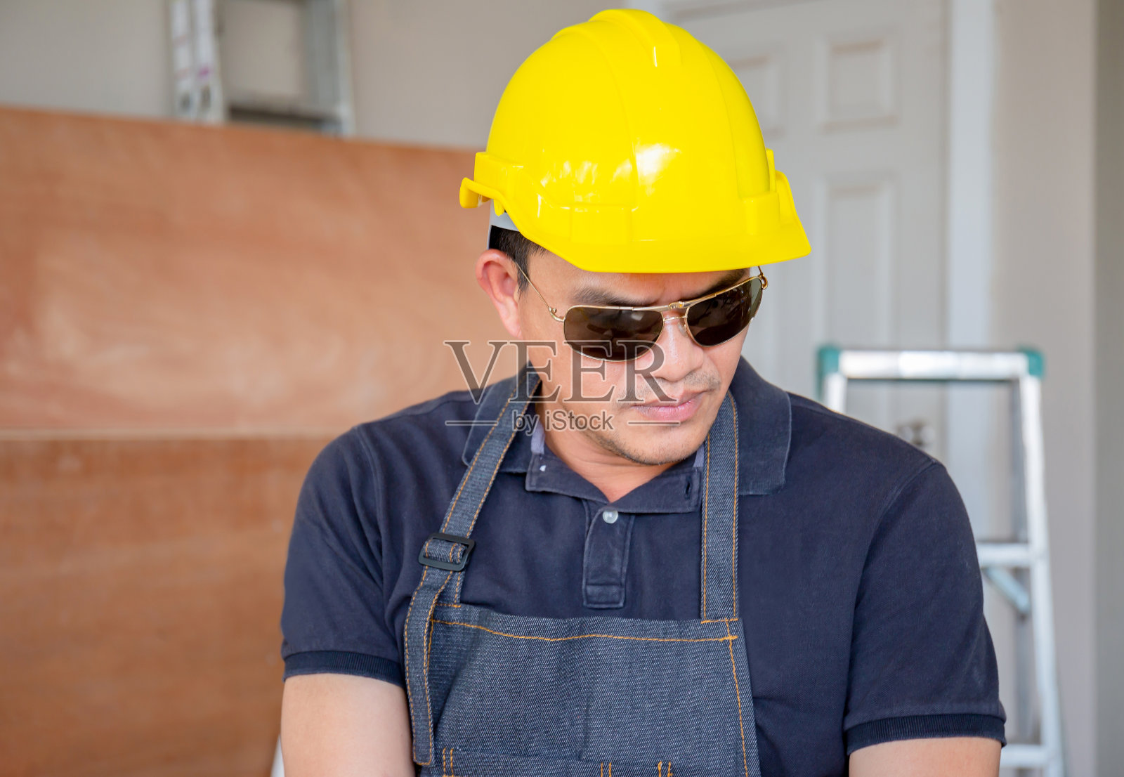 年轻人戴着安全帽站在木工车间里照片摄影图片