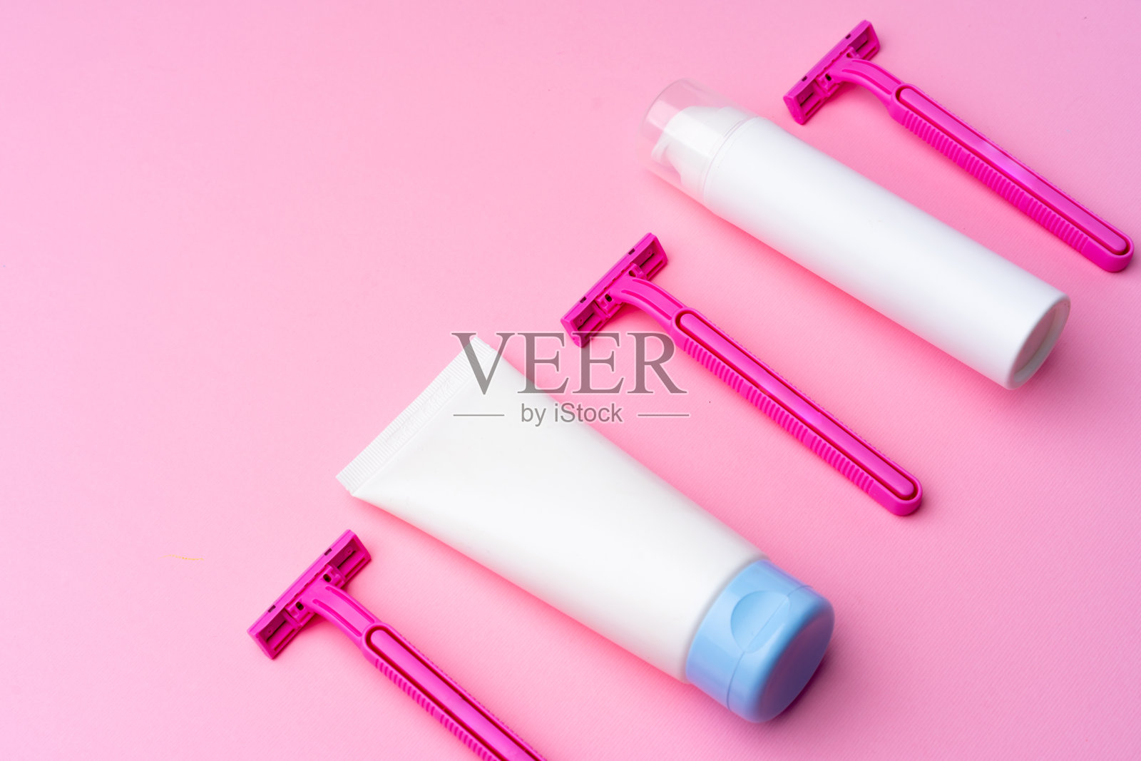 剃须凝胶和一次性剃须刀在粉红色的背景俯视图照片摄影图片