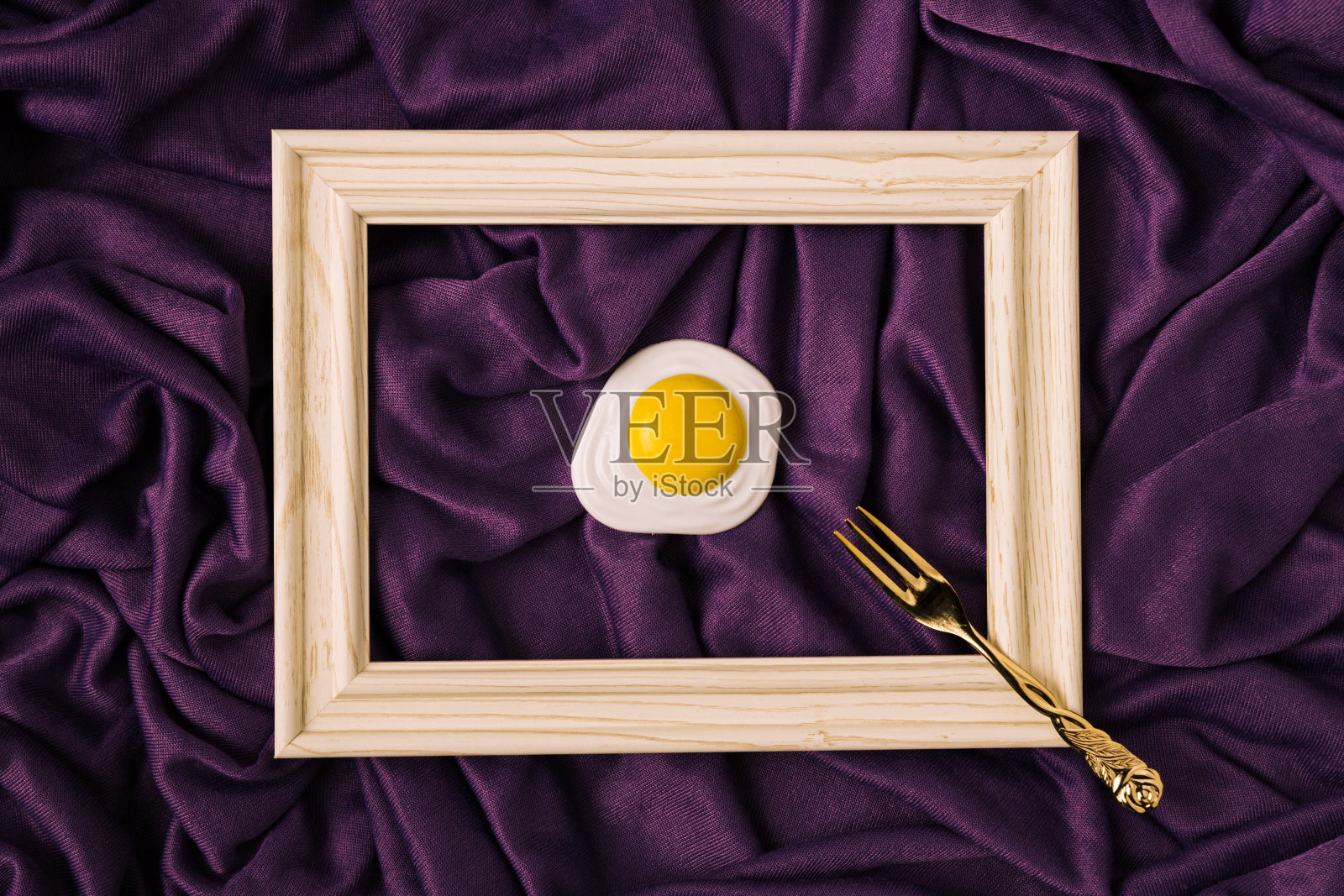 抽象概念的背蛋用金叉在木框上衬托出典雅奢华的紫色绸缎或绸缎的波浪背景。照片摄影图片