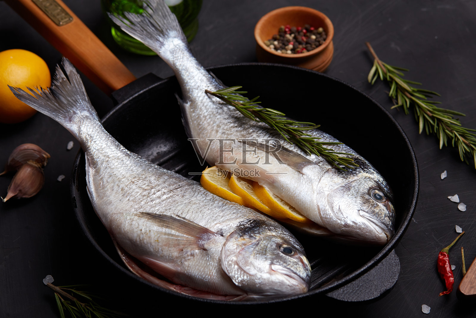 用柠檬和香草烹饪剑鱼的过程。照片摄影图片