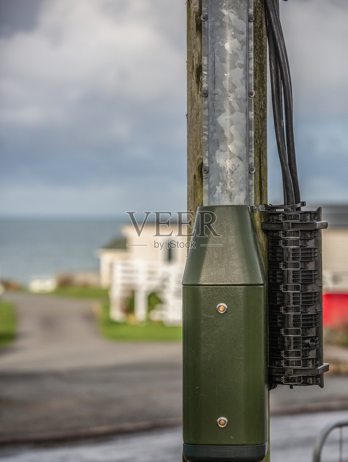 用于供应给住宅建筑的电气箱和配电电缆固定在钢杆上照片摄影图片