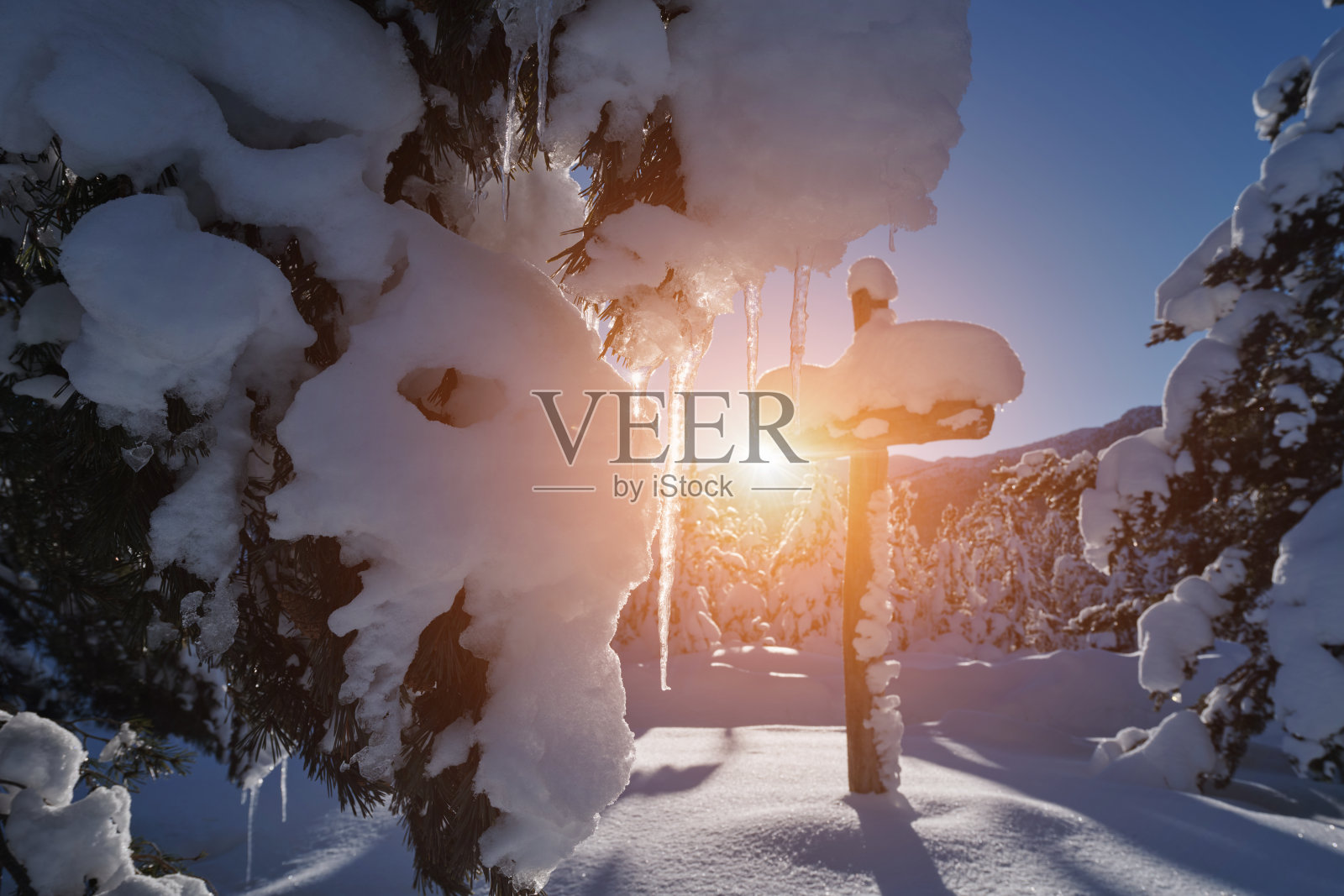 在美丽清新的冬天早晨，木制十字架覆盖着新鲜的雪照片摄影图片