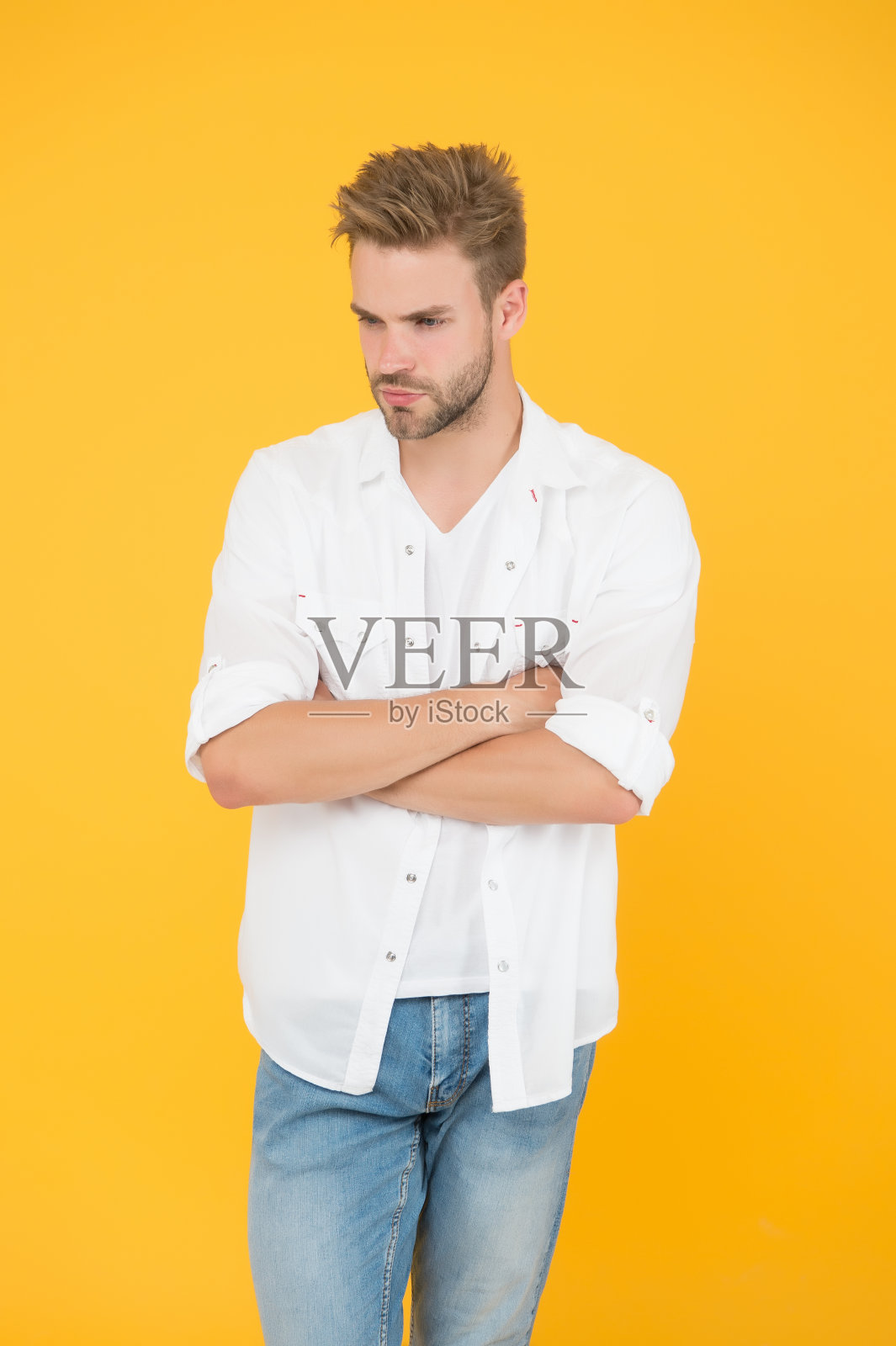 时尚与人的概念。性感和英俊。穿着牛仔裤衬衫的自信年轻英俊的男人。穿牛仔裤和t恤的人。穿白衬衫的男人。肌肉男在牛仔裤黄色背景。年轻和自由照片摄影图片